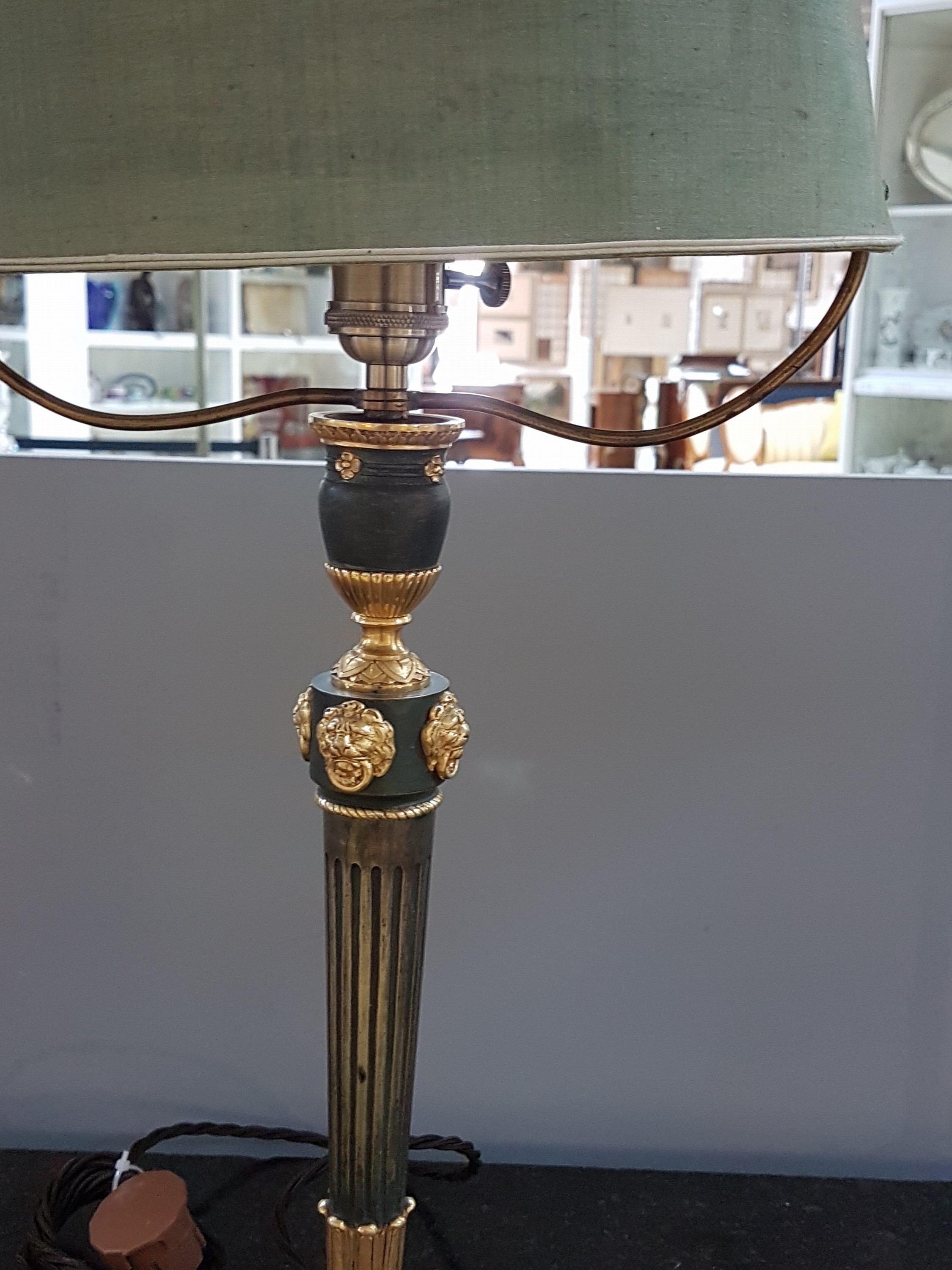 Detail b: Tischlampe, Frankreich, um 1900, Empirestil, Bronze teils grün patiniert, die reliefierten Löwenköpfe und Lorbeerkränze vergoldet, Stoffschirm ...