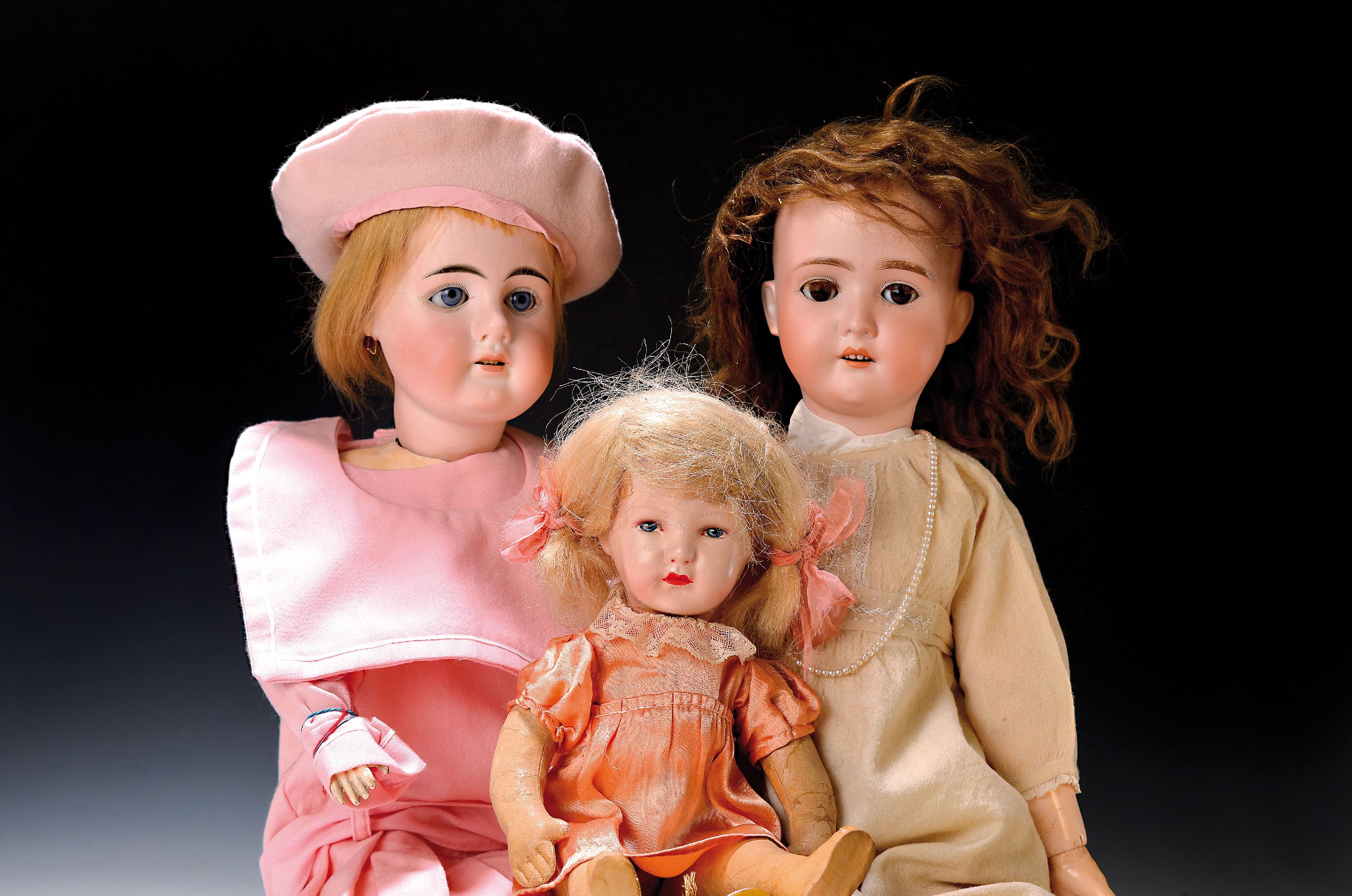 Drei Porzellankopfpuppen, Anfang 20. Jh., The Dollar Princess 62, braune Schlafaugen, offener Mund, vier Zähne, H. 60 cm; große Porzellankopfpuppe, ...