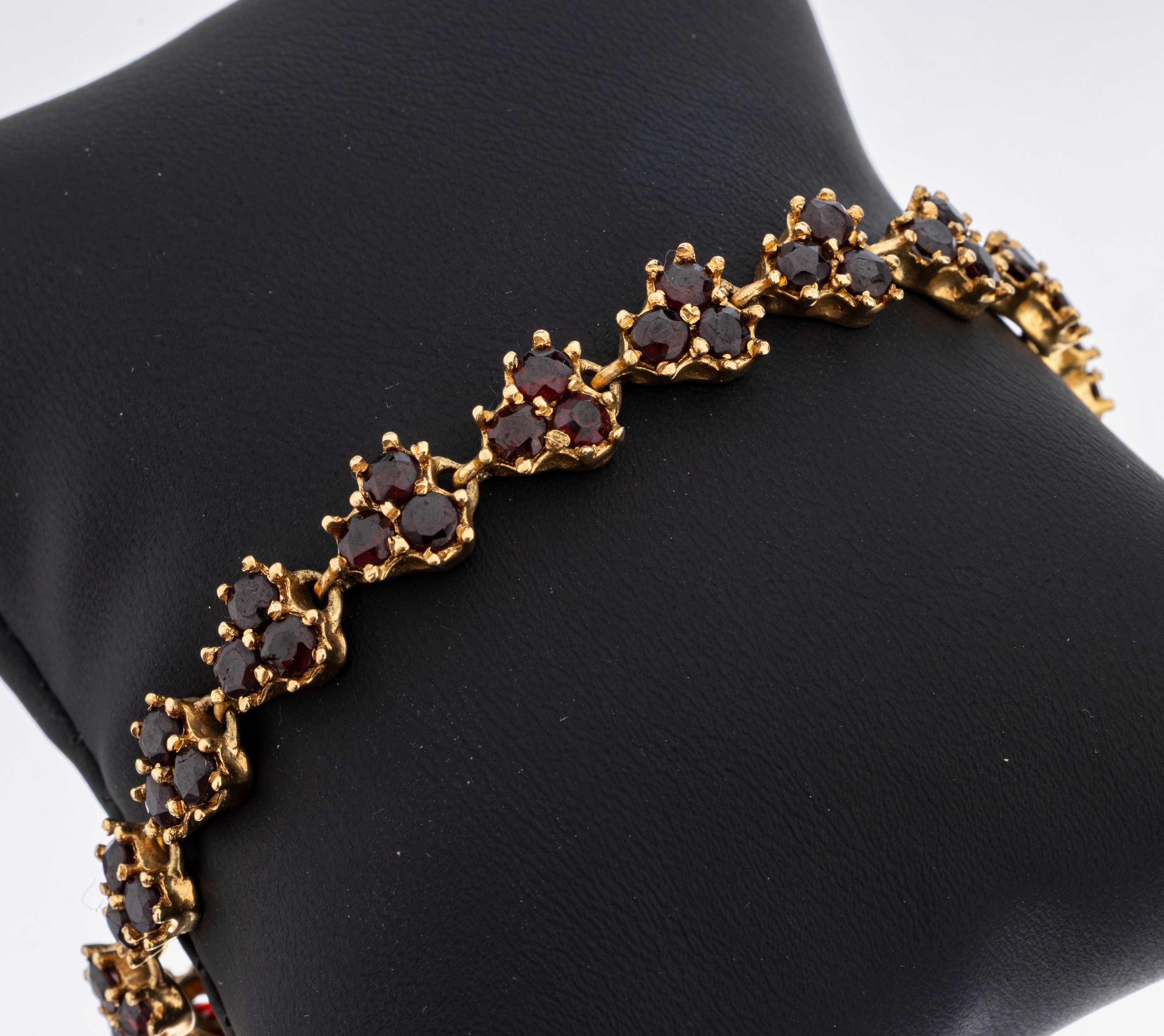 14 kt Gold Granat-Armband, GG 585/000, 16 einzelne Glieder mit jeweils 3 rundfacett. Granaten, L. ca. 17 cm, Kastenschloss mit Sicherheitsacht, ca. ...