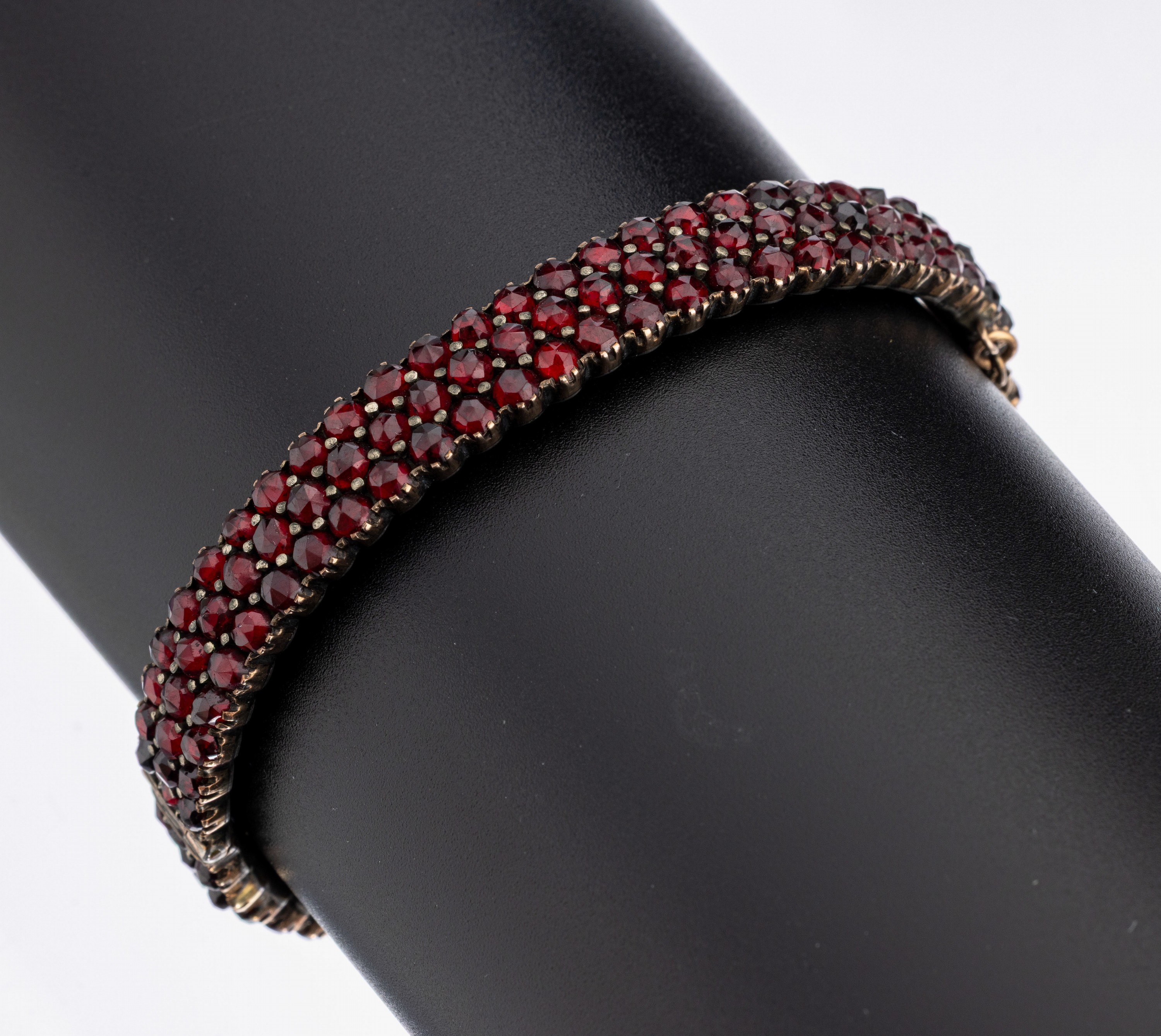Granat-Armband, um 1880-1900, Tombak, 3-rhg. rundfacett. Granate, D. ca. 5.3 x 4.2 cm, Klappscharnier, Kastenschloss mit Sicherheitskettchen
