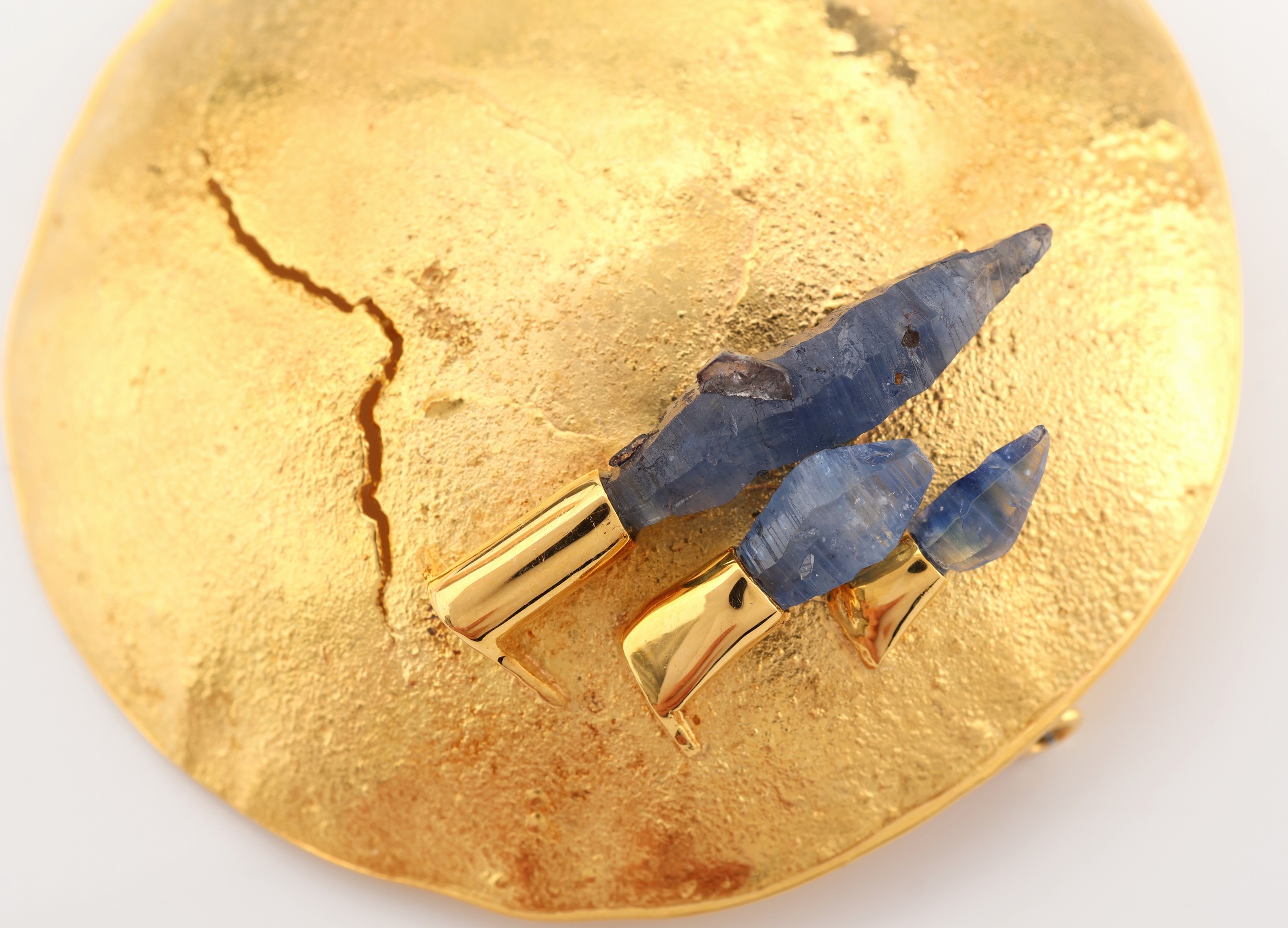 Detail a: 18 kt Gold Tansanit-Brosche, GG 750/000, Oberfläche strukturiert, rund, 3 Tansanit- Rohsteine, D. ca. 5.2 cm, ca. 23.3 g, Meistermarke unged.