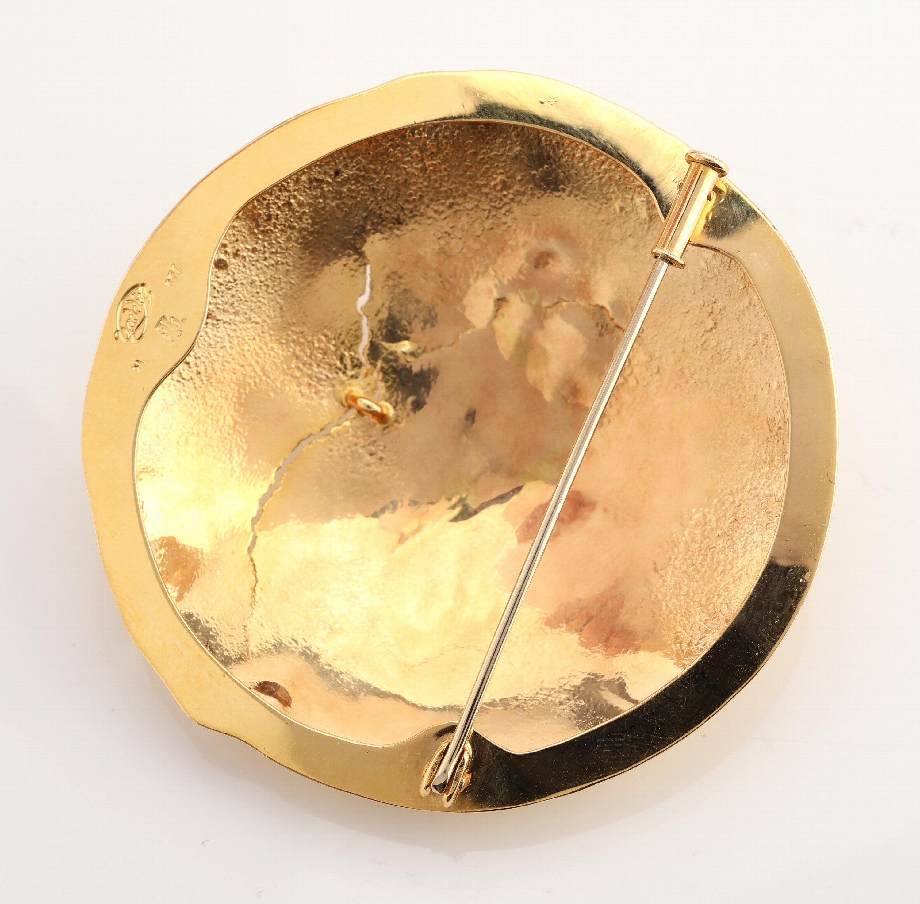 Detail b: 18 kt Gold Tansanit-Brosche, GG 750/000, Oberfläche strukturiert, rund, 3 Tansanit- Rohsteine, D. ca. 5.2 cm, ca. 23.3 g, Meistermarke unged.