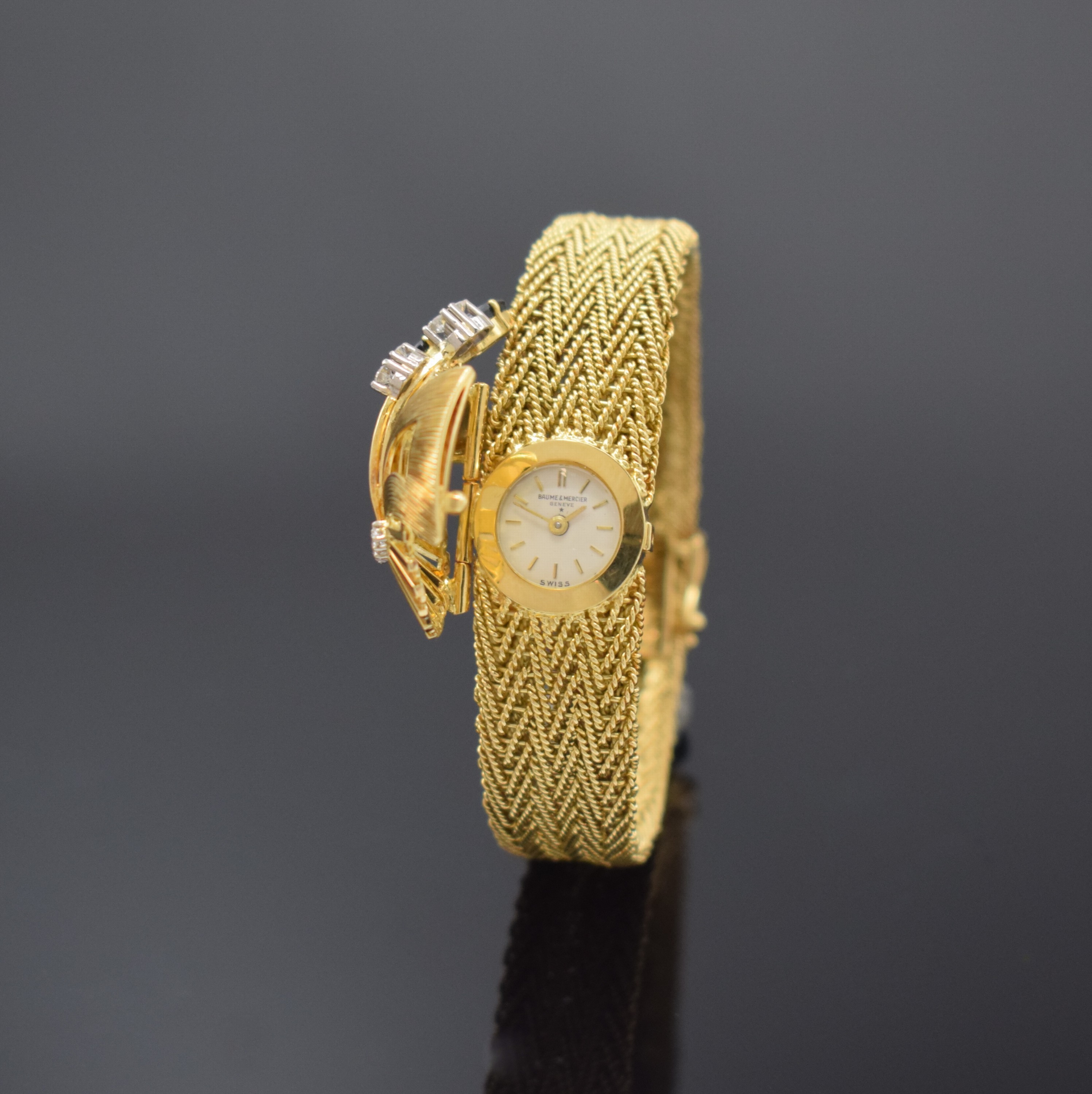 BAUME & MERCIER / ESZEHA aufwendige Damenarmbanduhr in GG 750/000, Schweiz um 1960, Handaufzug, aufklappbare Schmuckschutzkappe aufw. mit Diamanten ...