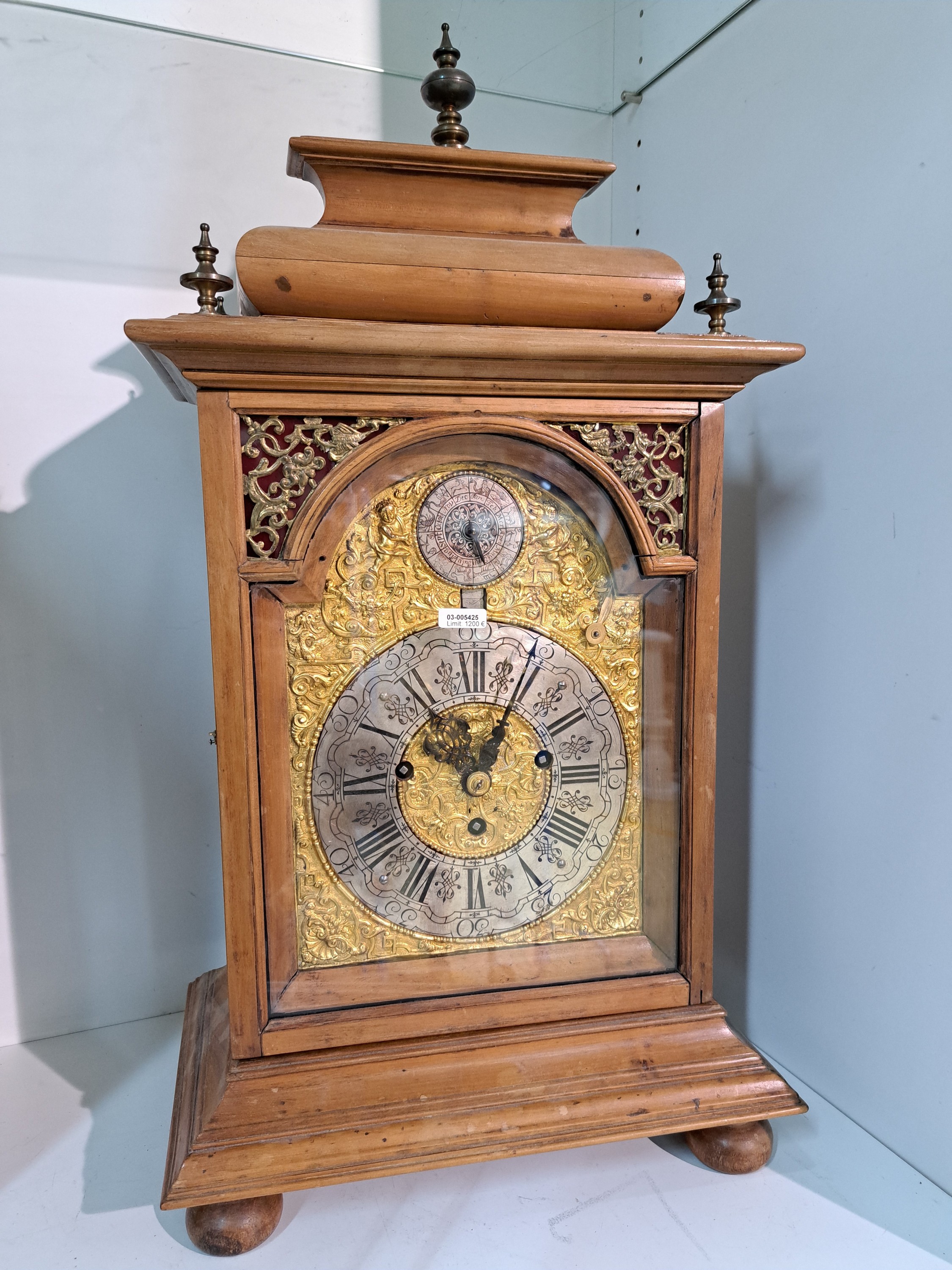 Detail d: Barockuhr, mit Carillon und Monat/Datumsanzeige, süddt. um 1780, Holzgehäuse reich profiliert, vierseitig verglast, verziertes Messingbogen ...