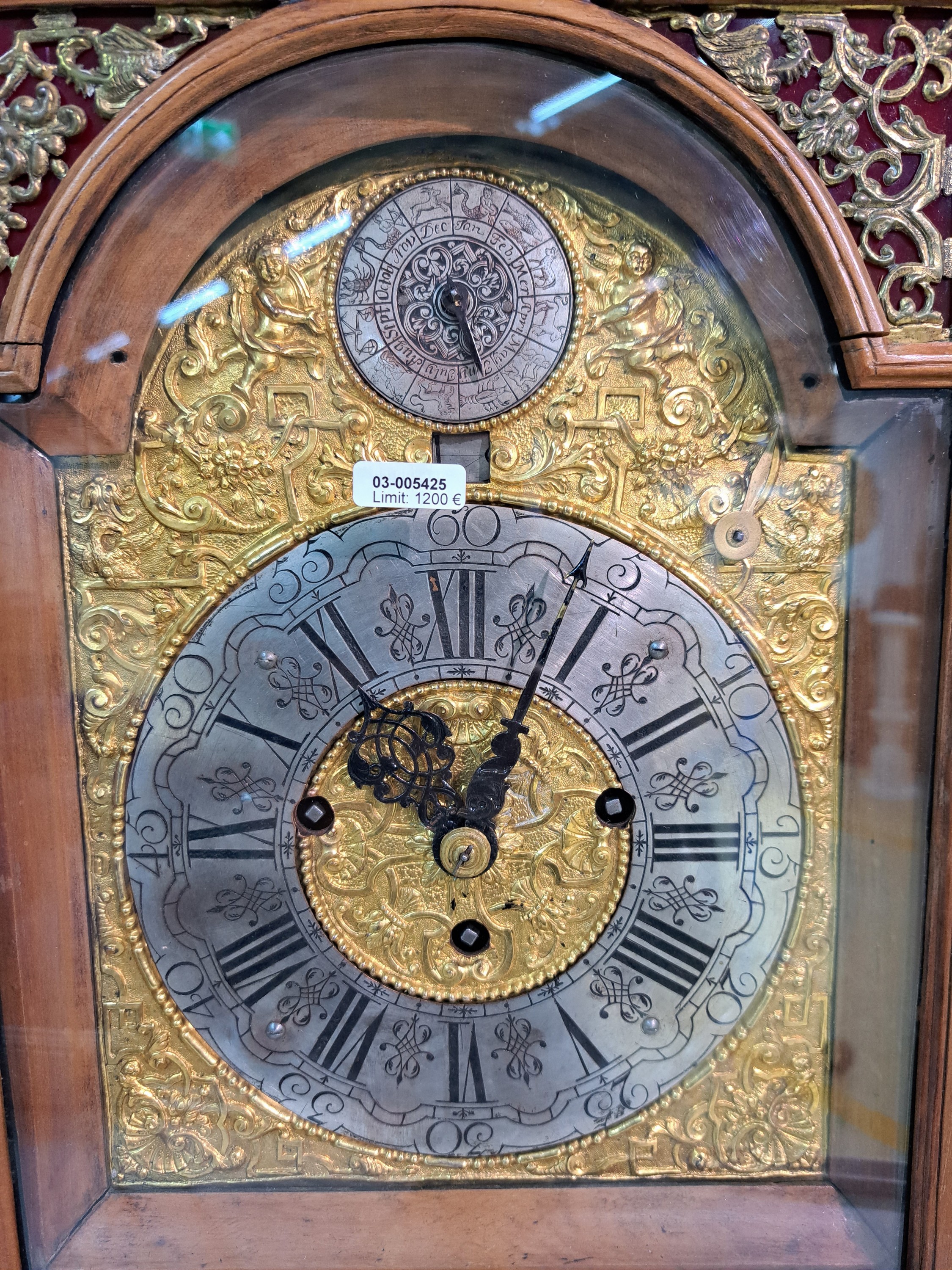 Detail e: Barockuhr, mit Carillon und Monat/Datumsanzeige, süddt. um 1780, Holzgehäuse reich profiliert, vierseitig verglast, verziertes Messingbogen ...