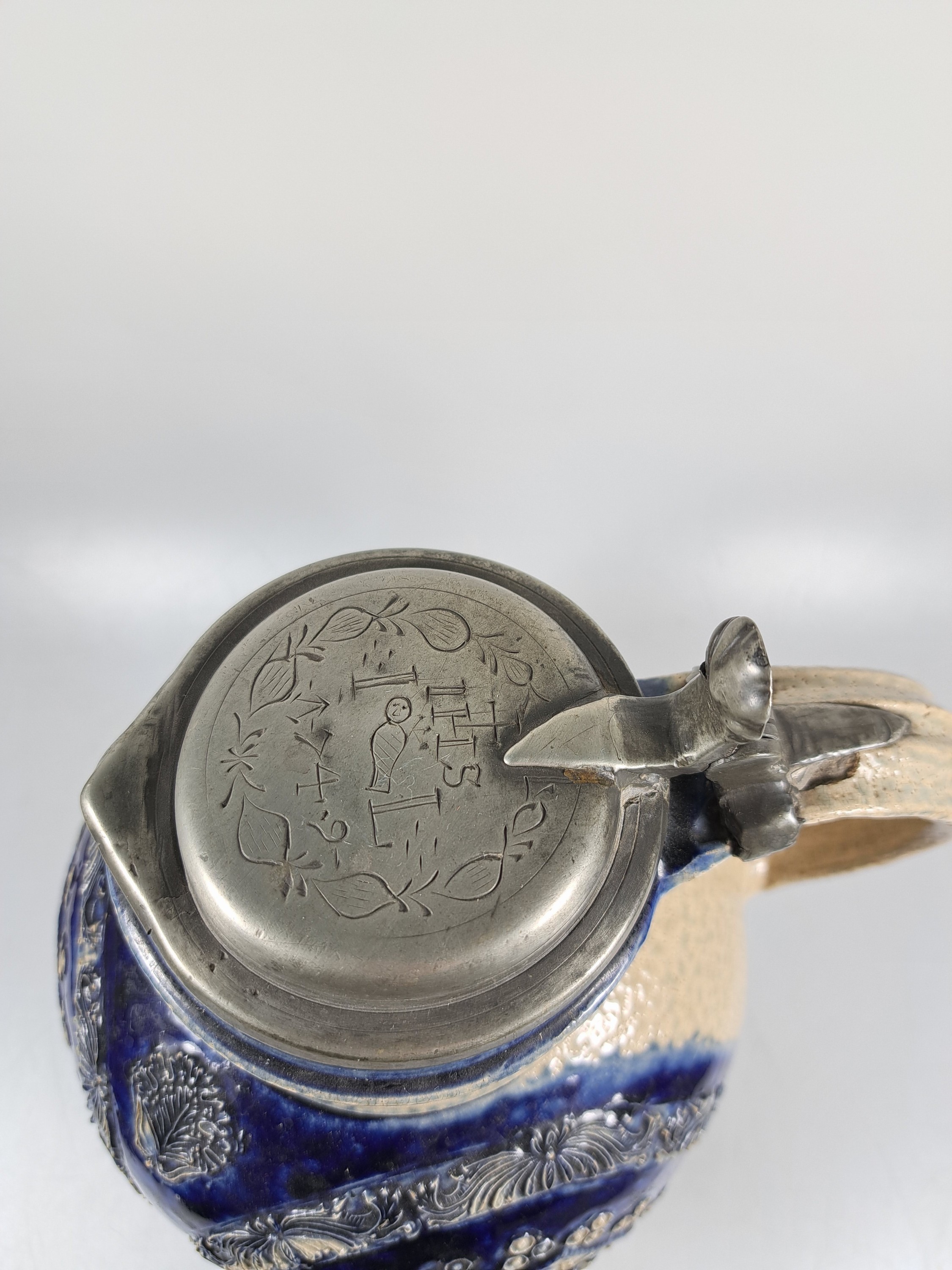 Detail e: Kugelbauchkrug, Westerwald, dat. 1749, Steinzeug, dreiseitiges Wappen, reich verziert, blaue Bemalung, orig. Zinndeckel mit IHS und Datierung, H. ca. ...