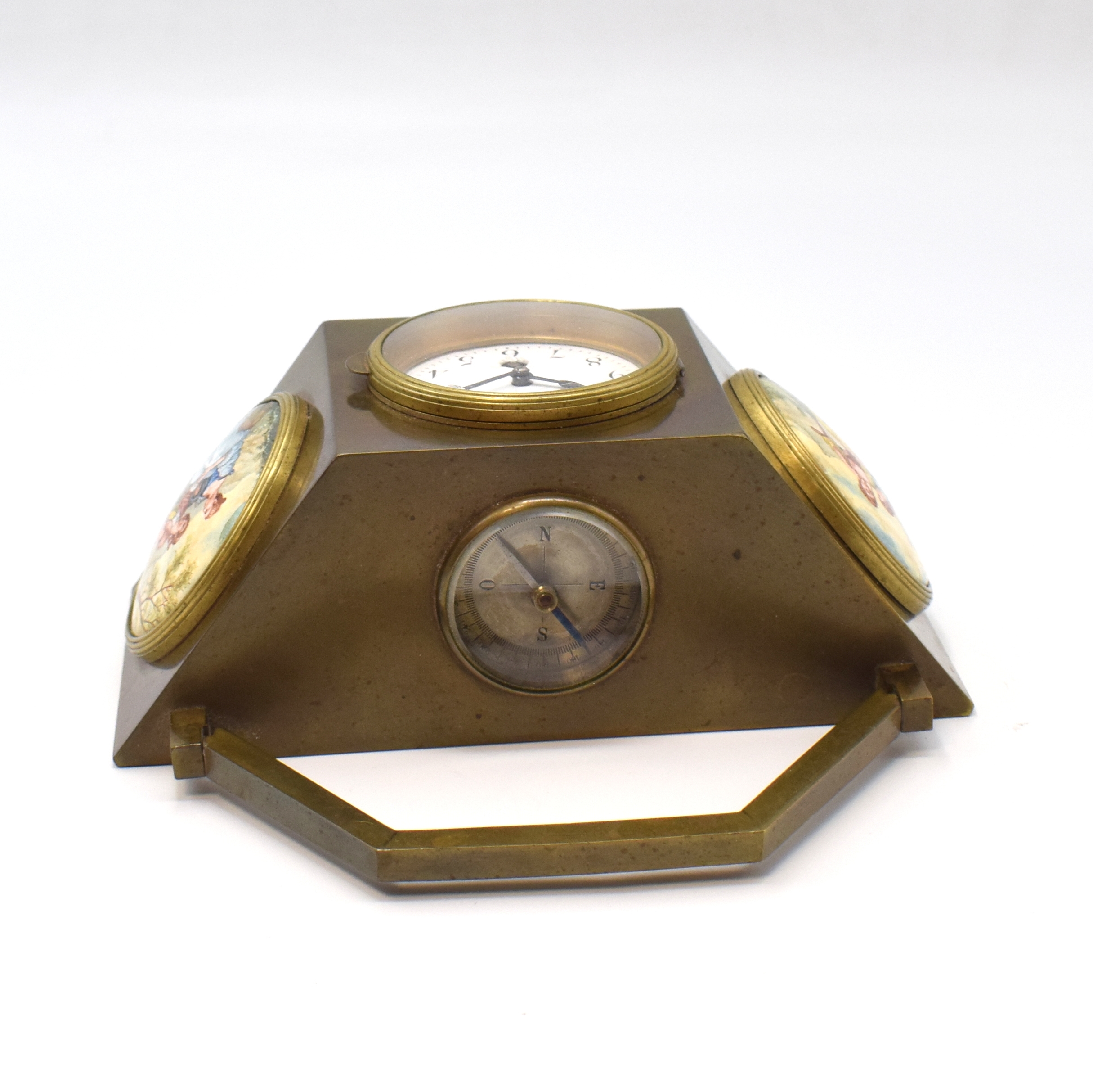 Detail d: Reiseuhr aus Bronze, um 1900, polygonales Gehäuse, in der Mitte die Uhr, Emailzifferbl. m. arab. Std. riss., gebl. Stahlz., links und rechts ...