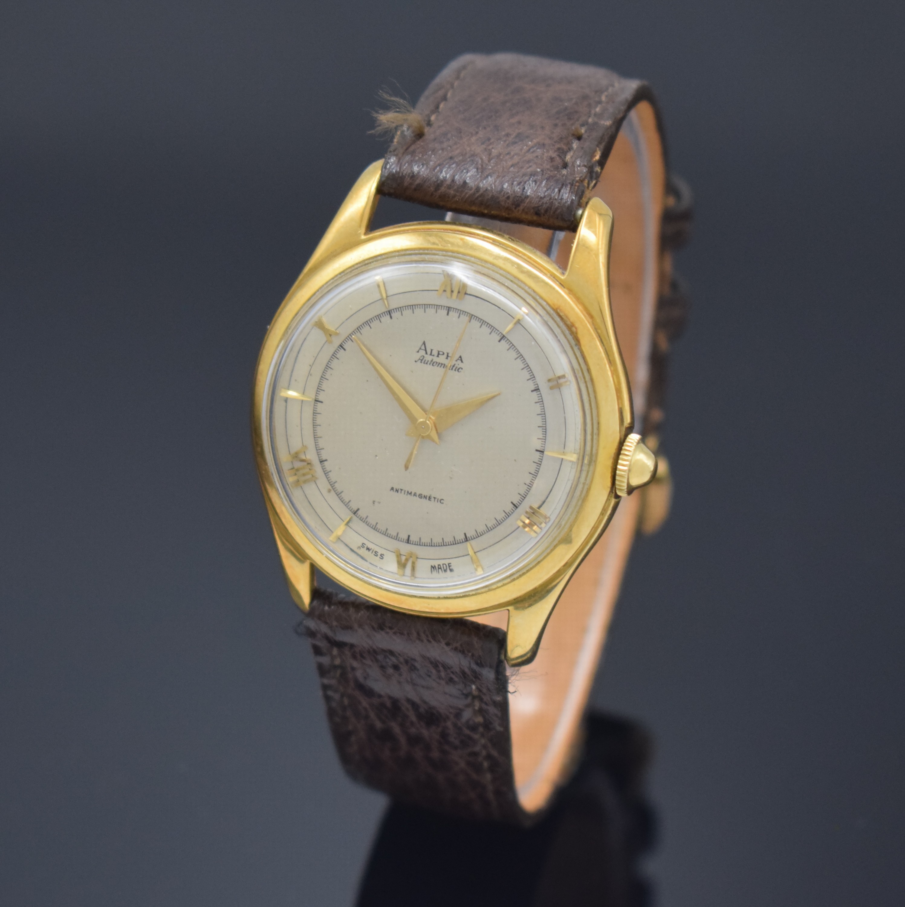 ALPHA Armbanduhr mit Hammerautomatik in GG 750/000, Schweiz um 1945, Boden aufgedr., silb. Duoton-Zifferbl. pat., aufges. gold. röm. Zahlen u. ...