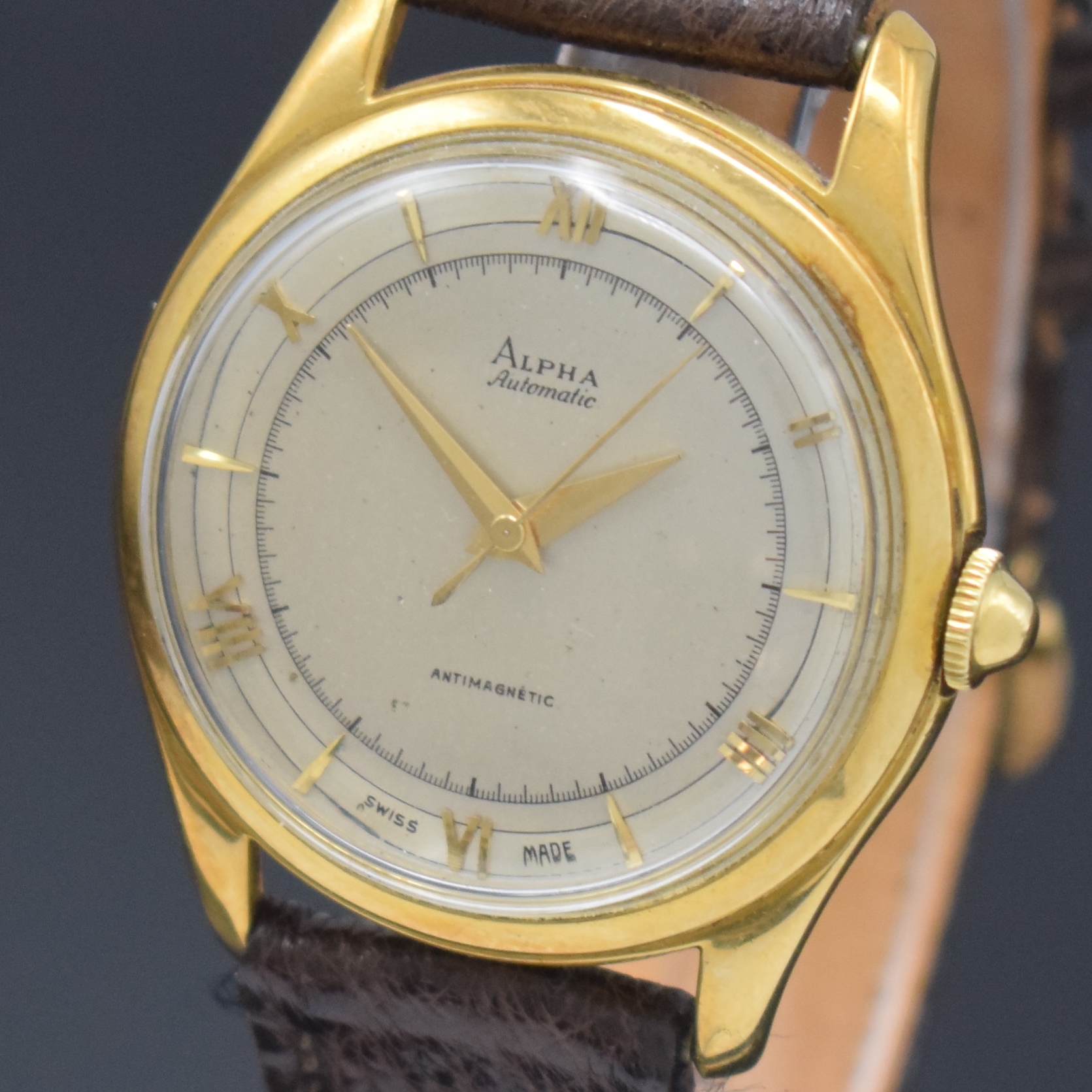 Detail a: ALPHA Armbanduhr mit Hammerautomatik in GG 750/000, Schweiz um 1945, Boden aufgedr., silb. Duoton-Zifferbl. pat., aufges. gold. röm. Zahlen u. ...