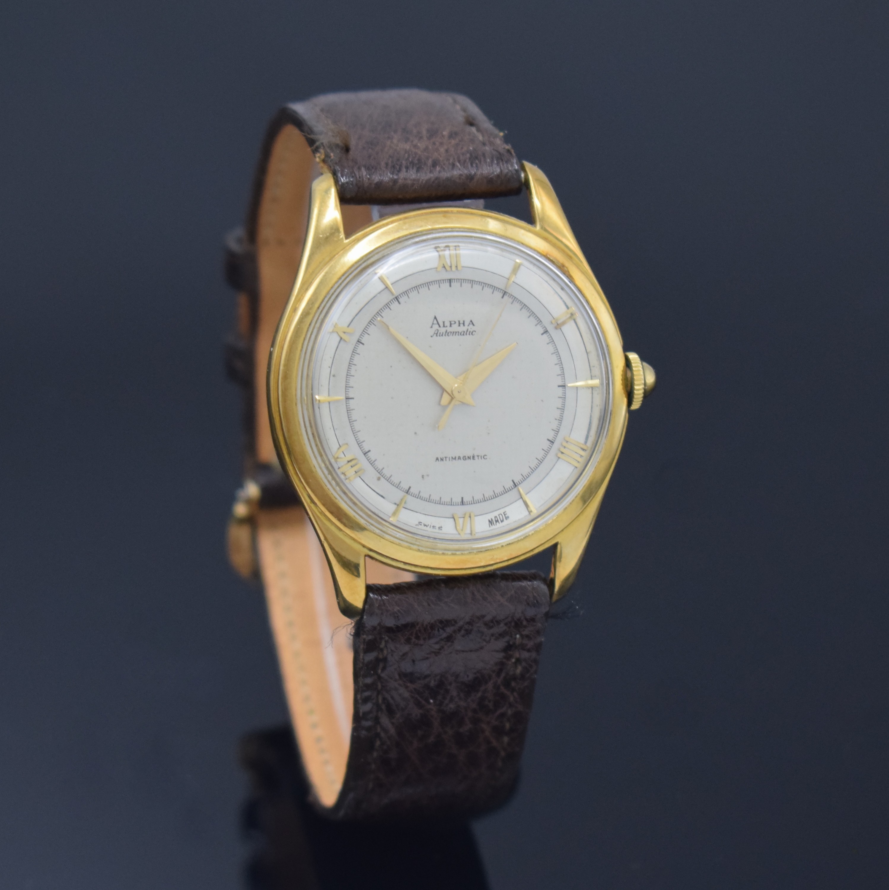 Detail b: ALPHA Armbanduhr mit Hammerautomatik in GG 750/000, Schweiz um 1945, Boden aufgedr., silb. Duoton-Zifferbl. pat., aufges. gold. röm. Zahlen u. ...