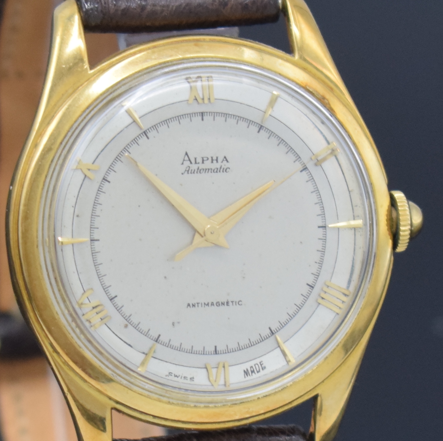 Detail c: ALPHA Armbanduhr mit Hammerautomatik in GG 750/000, Schweiz um 1945, Boden aufgedr., silb. Duoton-Zifferbl. pat., aufges. gold. röm. Zahlen u. ...