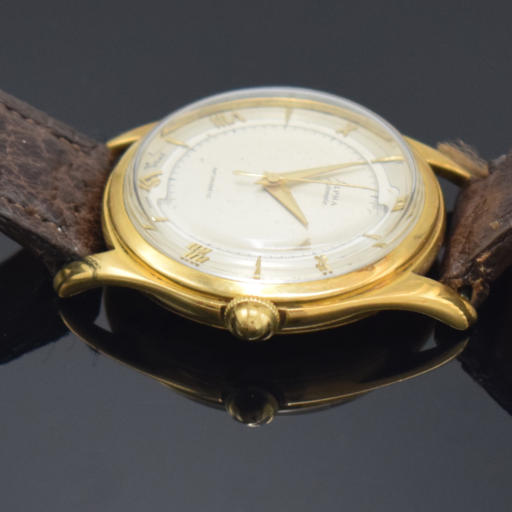 Detail e: ALPHA Armbanduhr mit Hammerautomatik in GG 750/000, Schweiz um 1945, Boden aufgedr., silb. Duoton-Zifferbl. pat., aufges. gold. röm. Zahlen u. ...