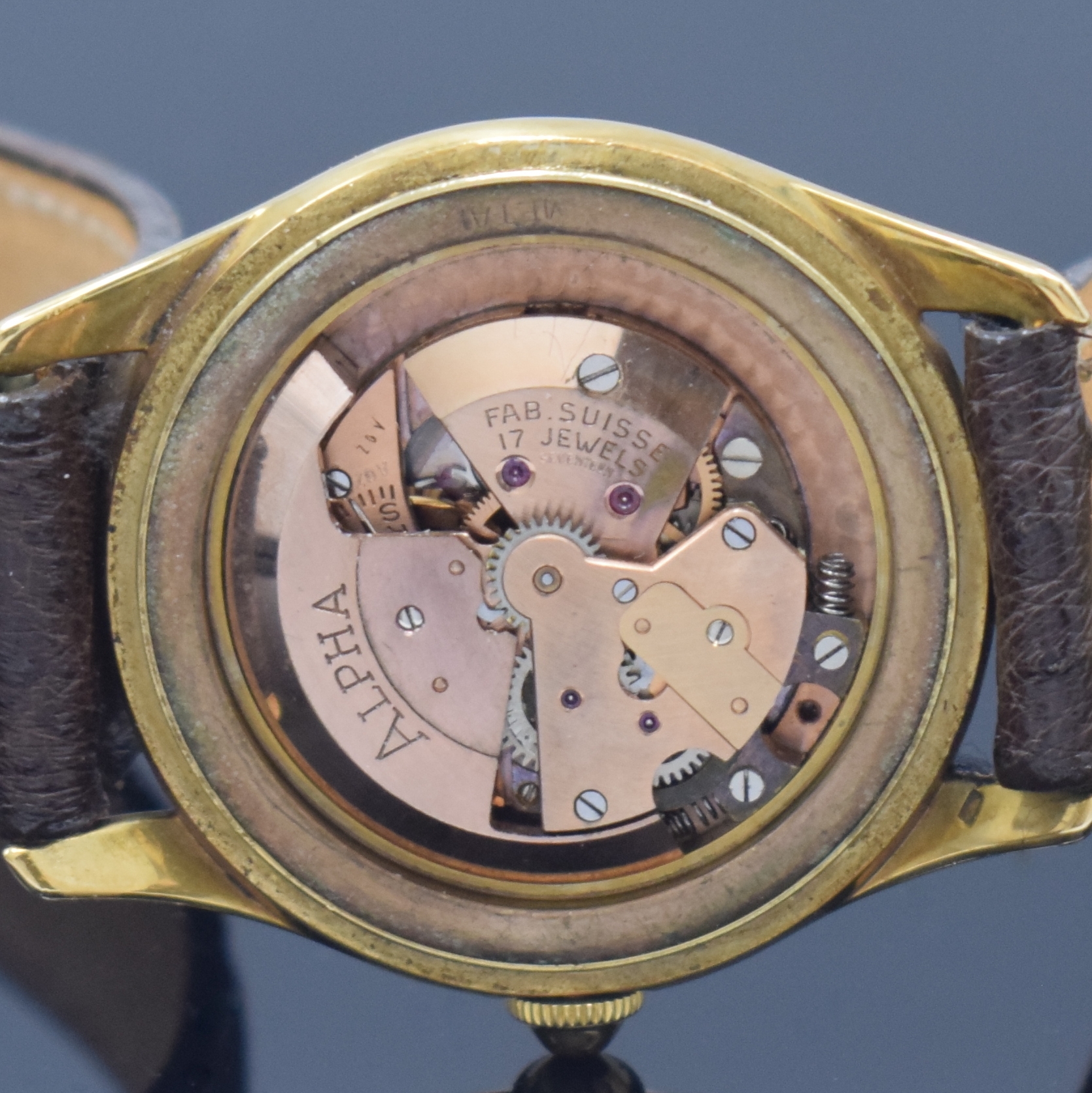 Detail h: ALPHA Armbanduhr mit Hammerautomatik in GG 750/000, Schweiz um 1945, Boden aufgedr., silb. Duoton-Zifferbl. pat., aufges. gold. röm. Zahlen u. ...