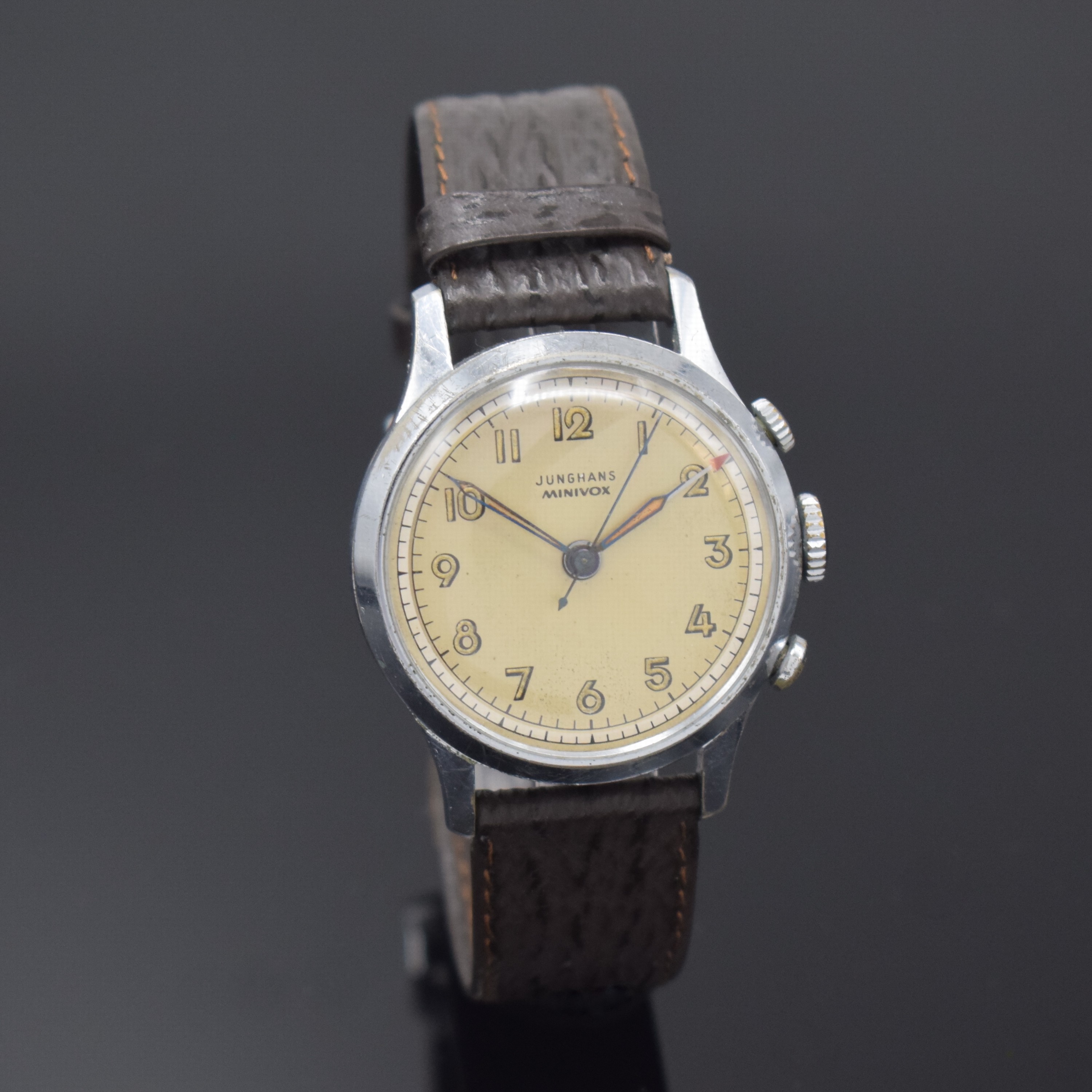Detail b: JUNGHANS Minivox Armbandwecker, Deutschland um 1950, Handaufzug, verchr. Geh., aufgedr. Stahlboden m. Membran, silb. Duoton-Zifferbl. arab. ...
