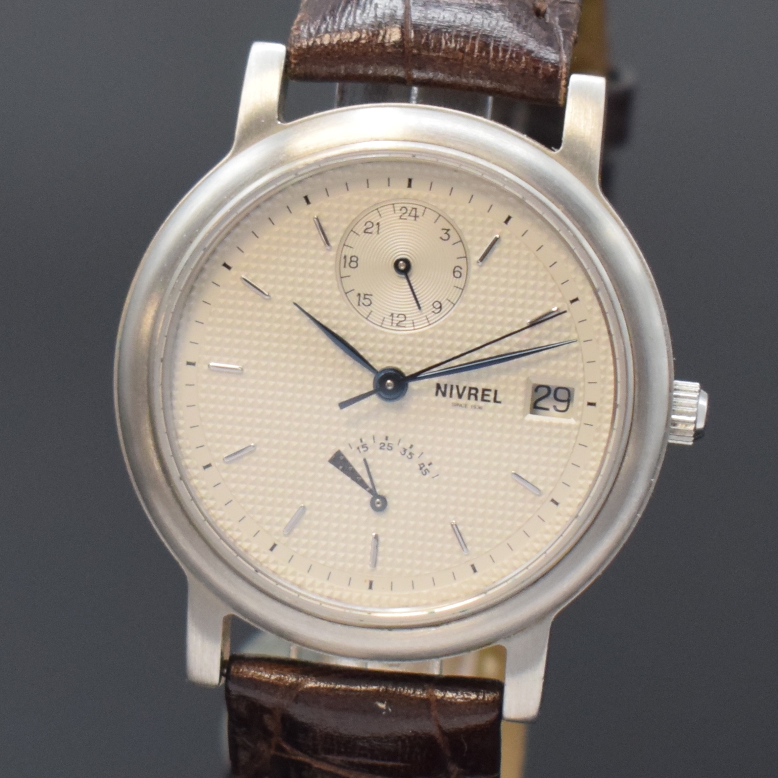 Detail a: NIVREL Armbanduhr mit Gangreserveanzeige und 2. Zeitzone, Schweiz um 1995, Automatik, beids. vergl. Geh., Boden u. Krone verschr., silb. ...