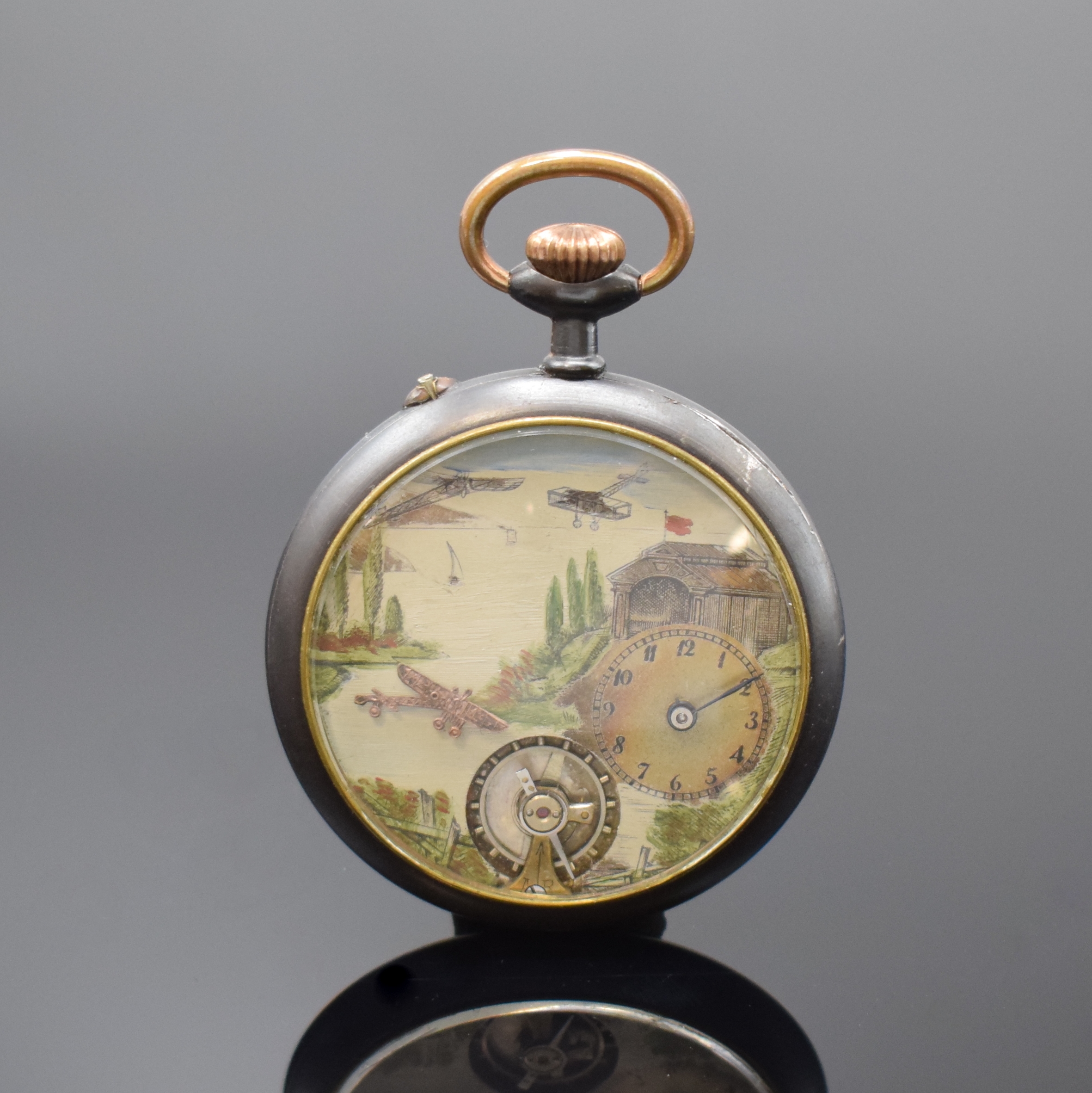 Offene Eisentaschenuhr mit dezentraler Zeitanzeige, um 1900, Monocogue-Geh., Glasrand aufgedr., Zifferblatt mit Flieger- Szenerie bemalt, dezentrale ...
