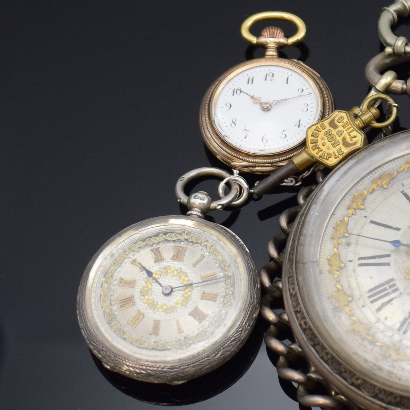 Detail a: 4 Taschenuhren in Silber, 1 x davon übergroßan Kette, Cuv. im Innern mit Eigentümergravur, reich graviertes und floral verziertes Gehäuse, Boden ...