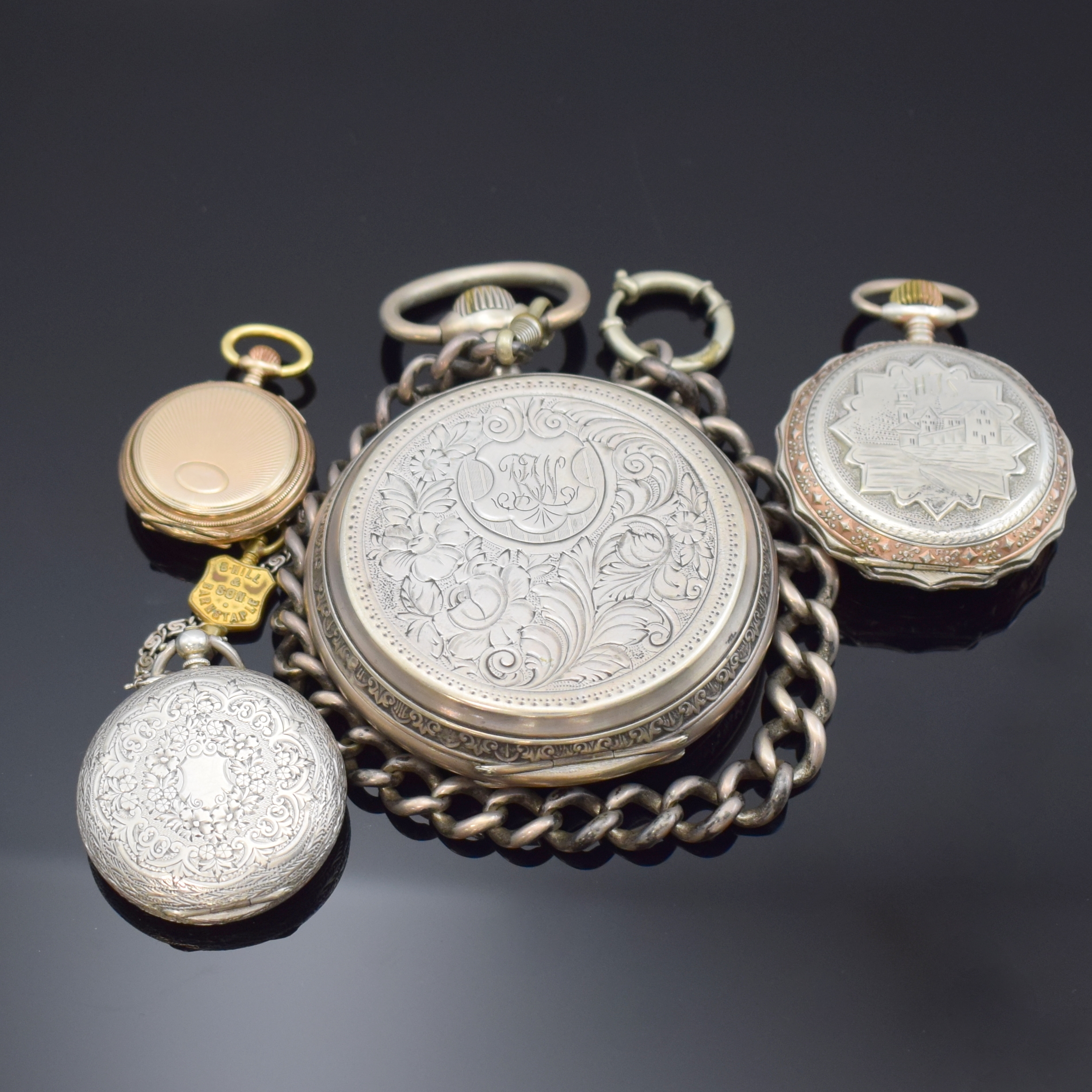 Detail c: 4 Taschenuhren in Silber, 1 x davon übergroßan Kette, Cuv. im Innern mit Eigentümergravur, reich graviertes und floral verziertes Gehäuse, Boden ...