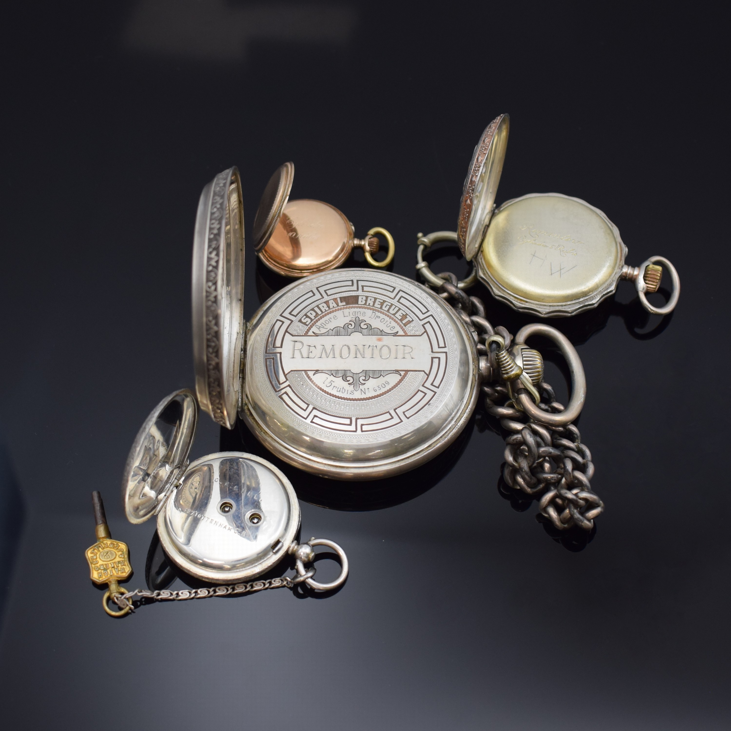 Detail d: 4 Taschenuhren in Silber, 1 x davon übergroßan Kette, Cuv. im Innern mit Eigentümergravur, reich graviertes und floral verziertes Gehäuse, Boden ...