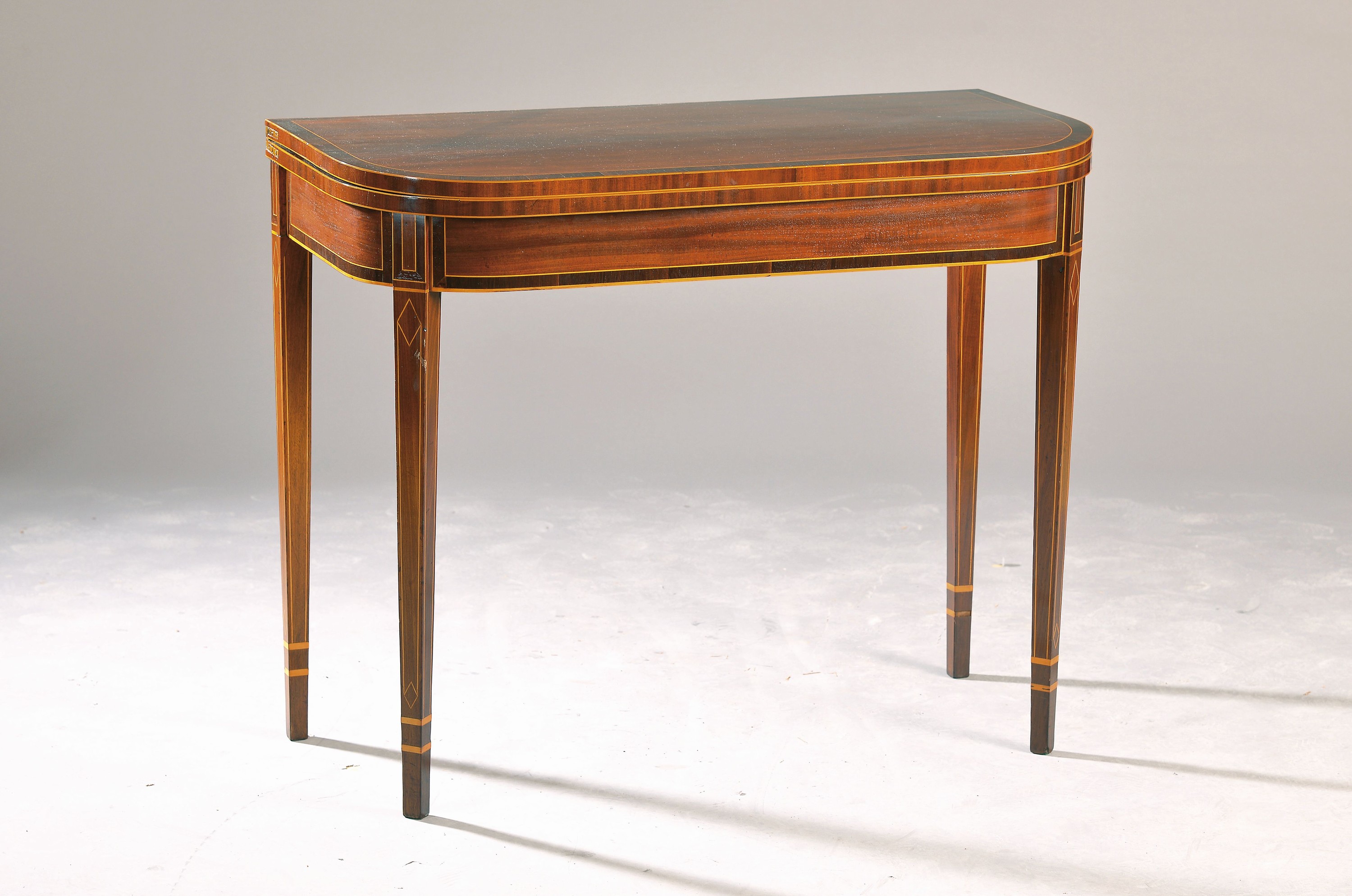 Feiner Konsolentisch/Spieltisch, norddeutsch, um 1820, Mahagonifurnier, Tischplatte aufklappbar, Innenseite mit blauem Tuch bezogen, Zarge und spitz ...
