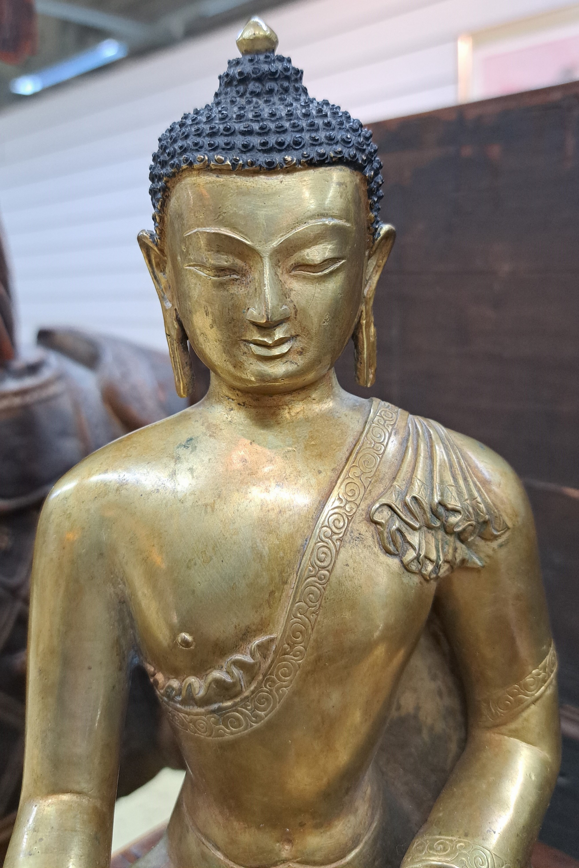 Detail b: Buddha Shakyamuni, Nepal, 19. Jh., Kupferlegierung, feuervergoldet, Mudra der Meditation und Erdberührung, H.ca. 27 cm