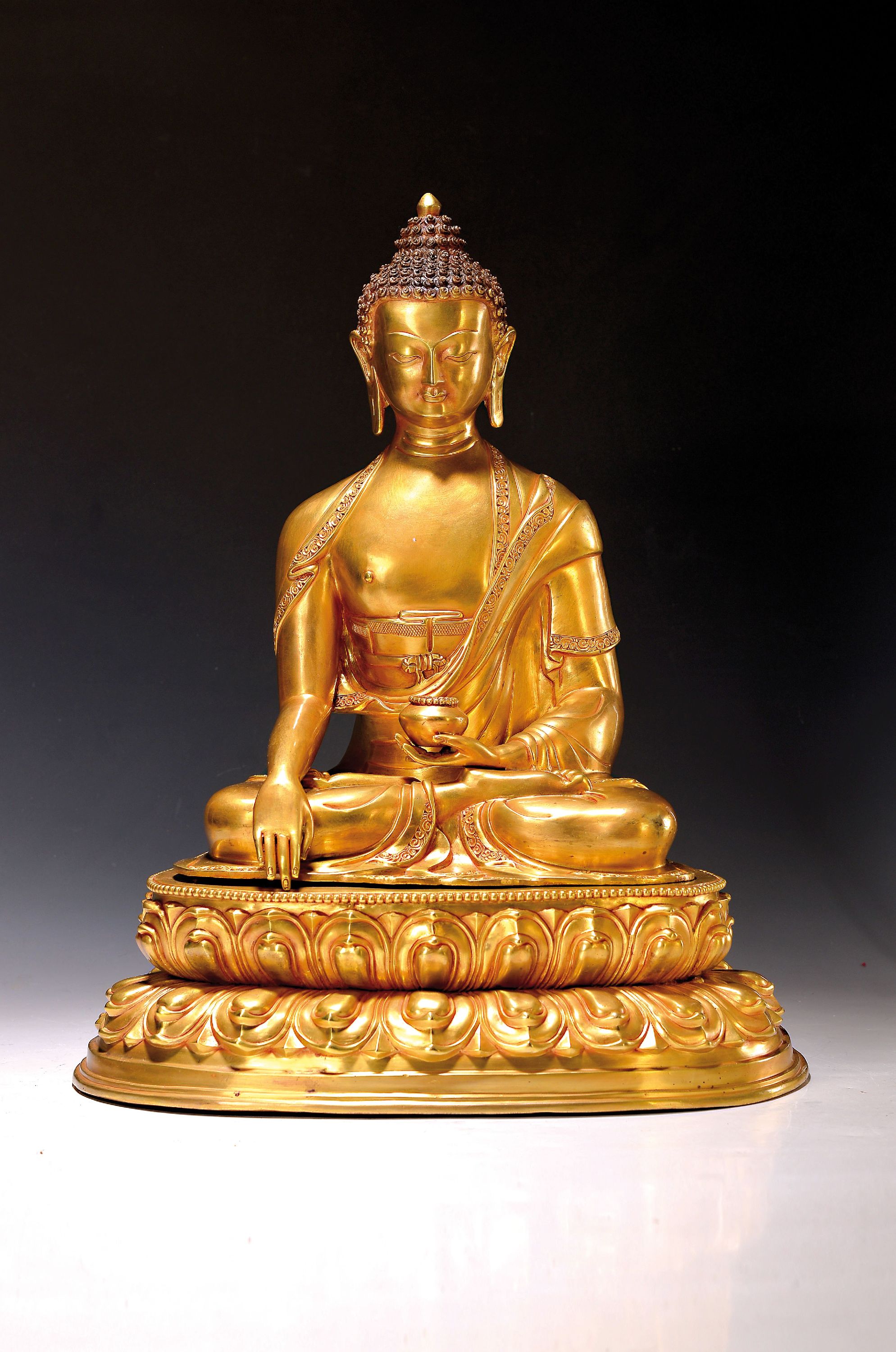 Buddha Shakyamuni, Nepal, Anfang 21. Jh., Kupferlegierung, feuervergoldet, in zwei Teilen gegossen, Mudra der Meditation u. Erdberührung, die Linke ...