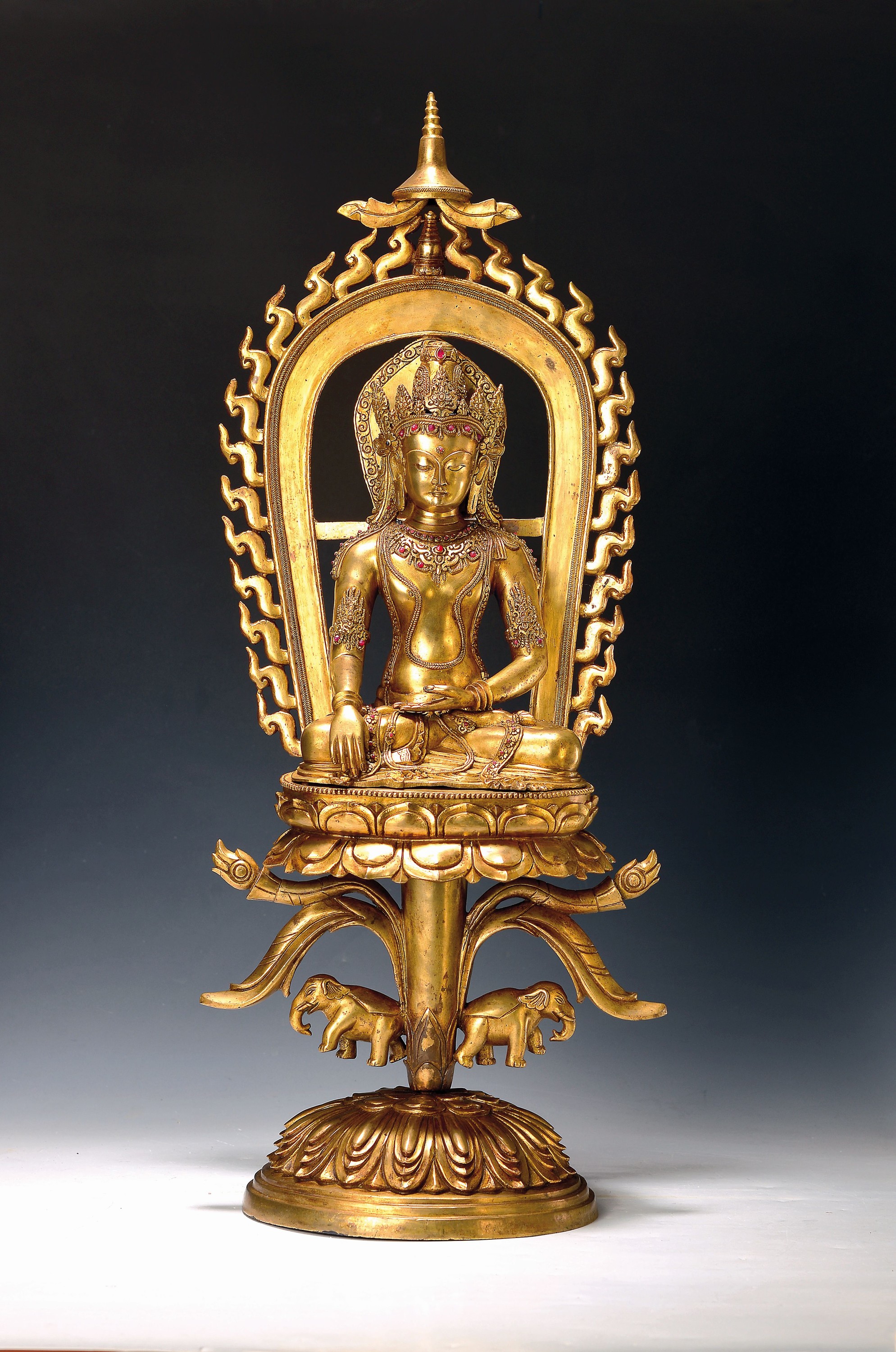 Altarskulptur des Tathagata Akshobhya auf hohem Lotus, Nepal, wohl um 1900, Kupferlegierung feuervergoldet, mehrteilig, separate Aureole, ...