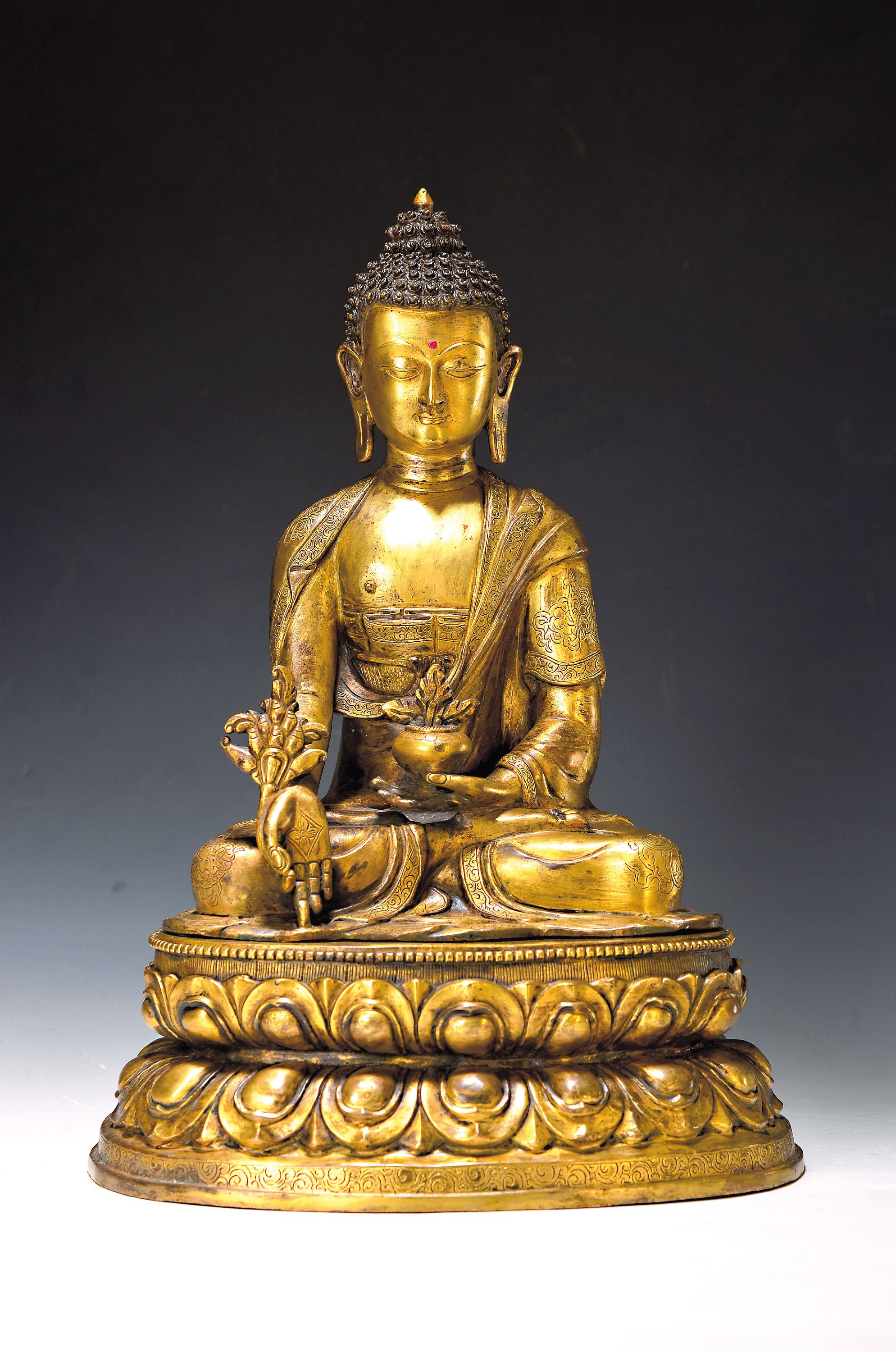 Medizinbuddha Bhaishayaguru, Nepal, 20.Jh., Kupferlegierung, feuervergoldet, Sockel u. Attribute, getrennt gegossen, in der rechten Hand hält er in ...