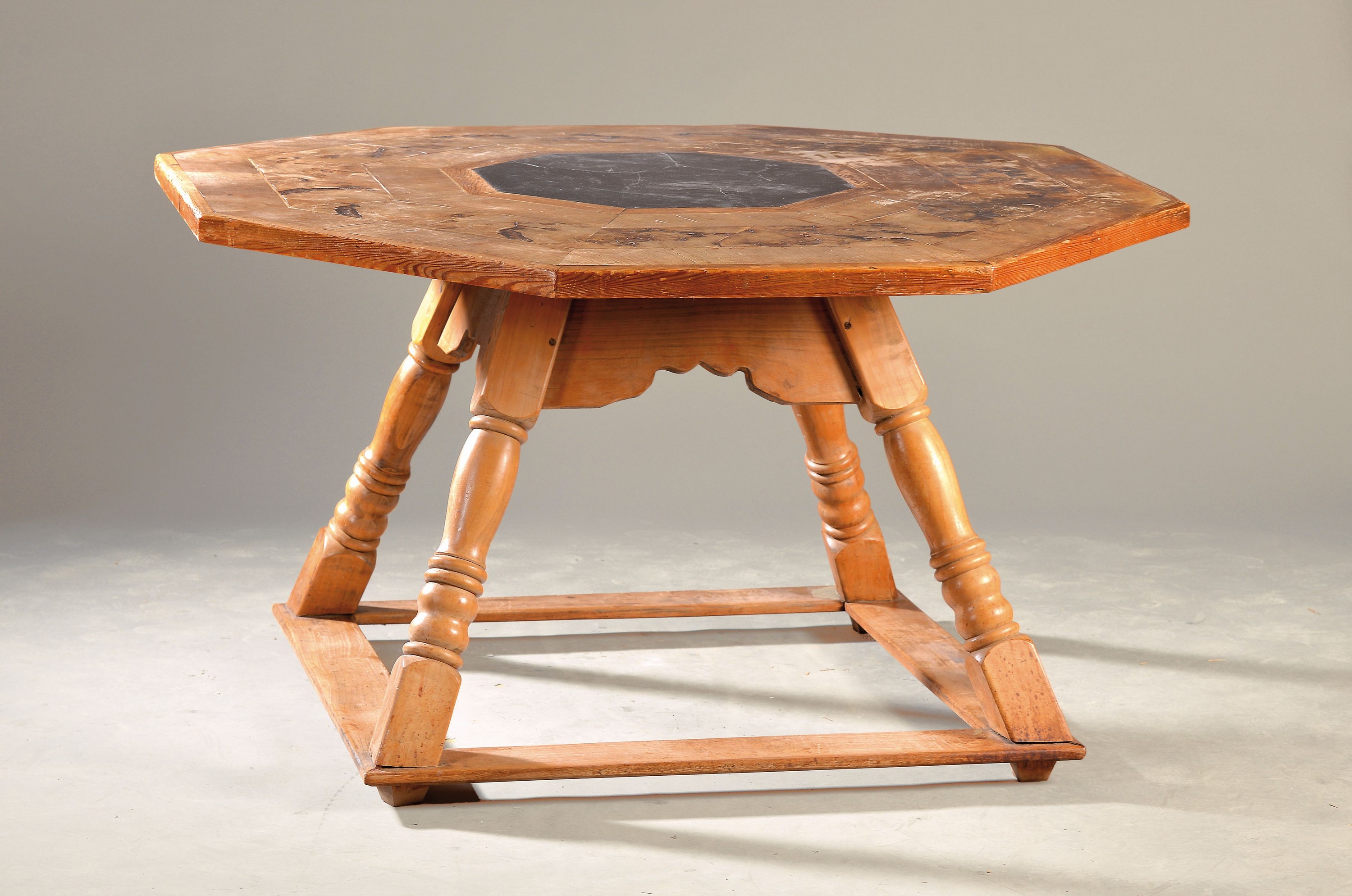 Großer Bauerntisch, Montafon, 18./19. Jh., Fichtenholzgestell/Fuß, Beine teilweise erneuert, achteckige Platte mit Nussbaumfurnier, ca. 75 x 134 x ...