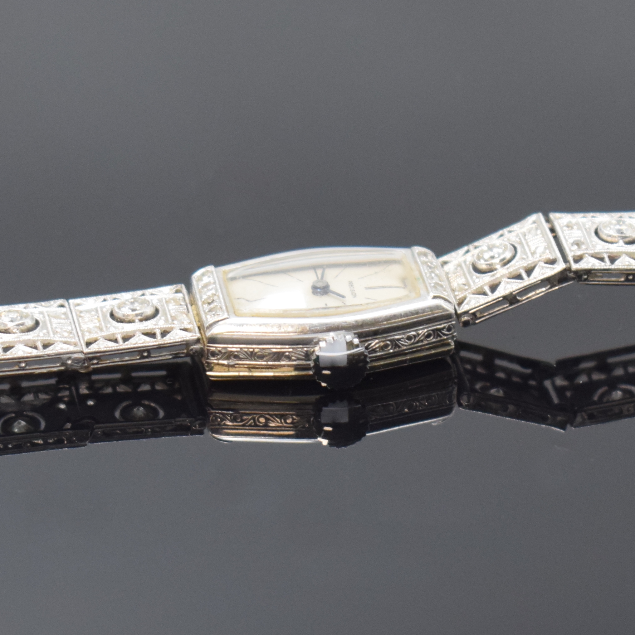 Detail b: Diamantbesetzte Art-Deco Damenarmbanduhr in WG 585/000, Schweiz um 1930, Handaufzug, Boden aufgedr., Milanaise an Band später, Geh. sowie Band m. ...