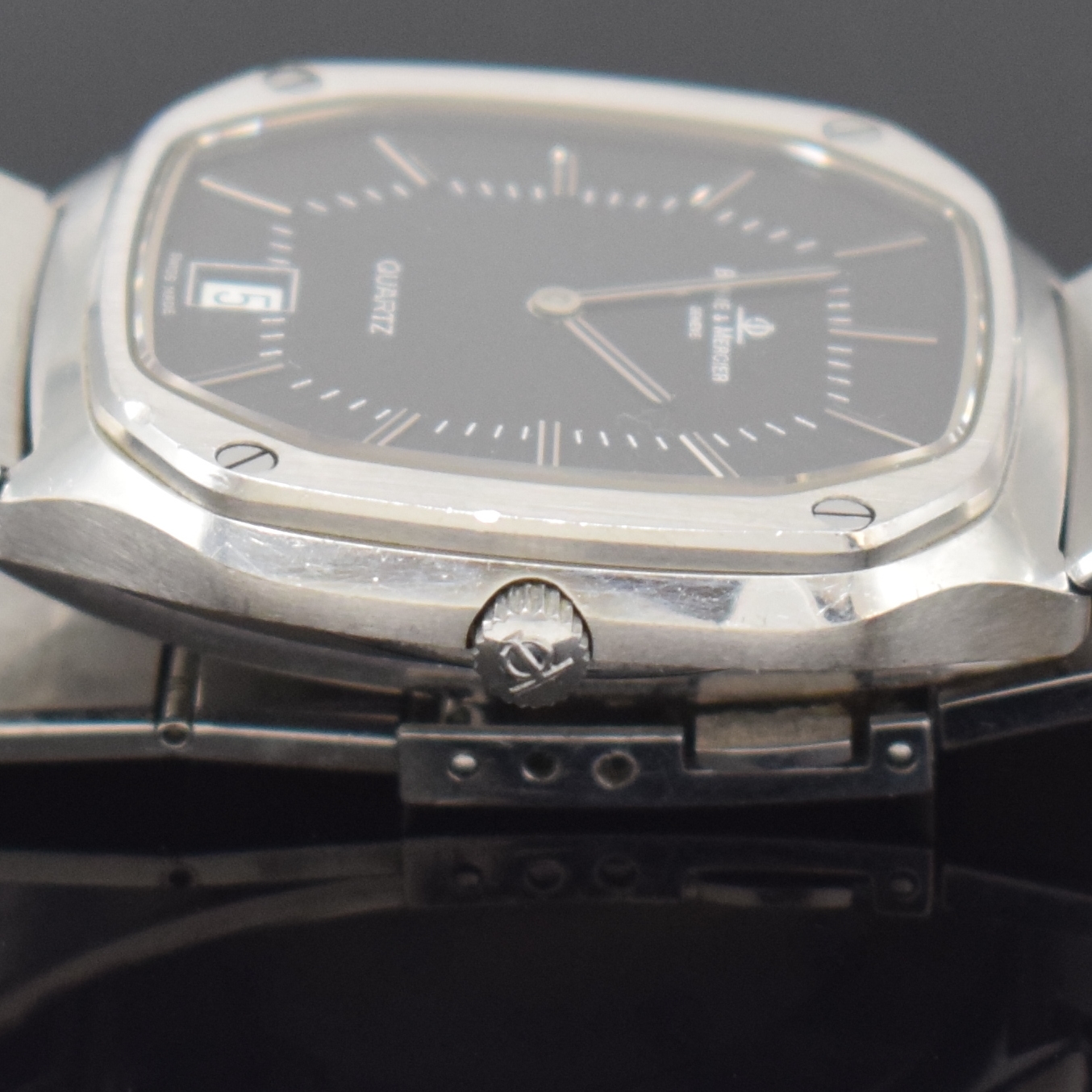 Detail e: BAUME & MERCIER Armbanduhr Referenz 4100, quarz, Schweiz um 1985, Edelstahlgeh. inkl. Gliederband m. Faltschl., Boden aufgedr., schwarzes Zifferbl., ...