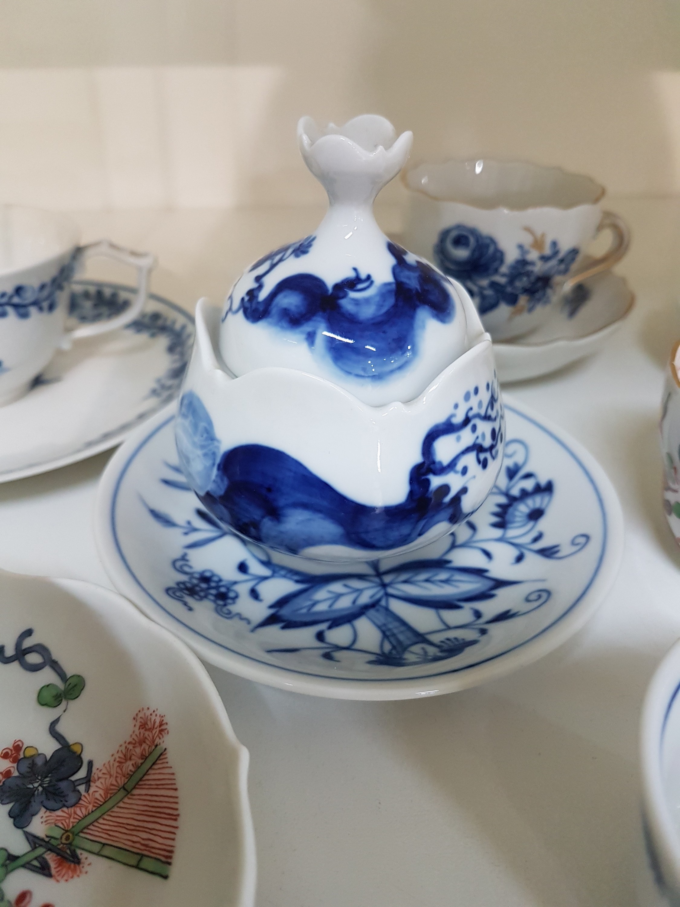 Detail b: 14 Teile Porzellan, Meissen, 20. Jh., 5 Mokkatassen mit Untertassen in den Dekoren Kakiemon, gestreute Blümchen, Indisch purpur, blaue ...