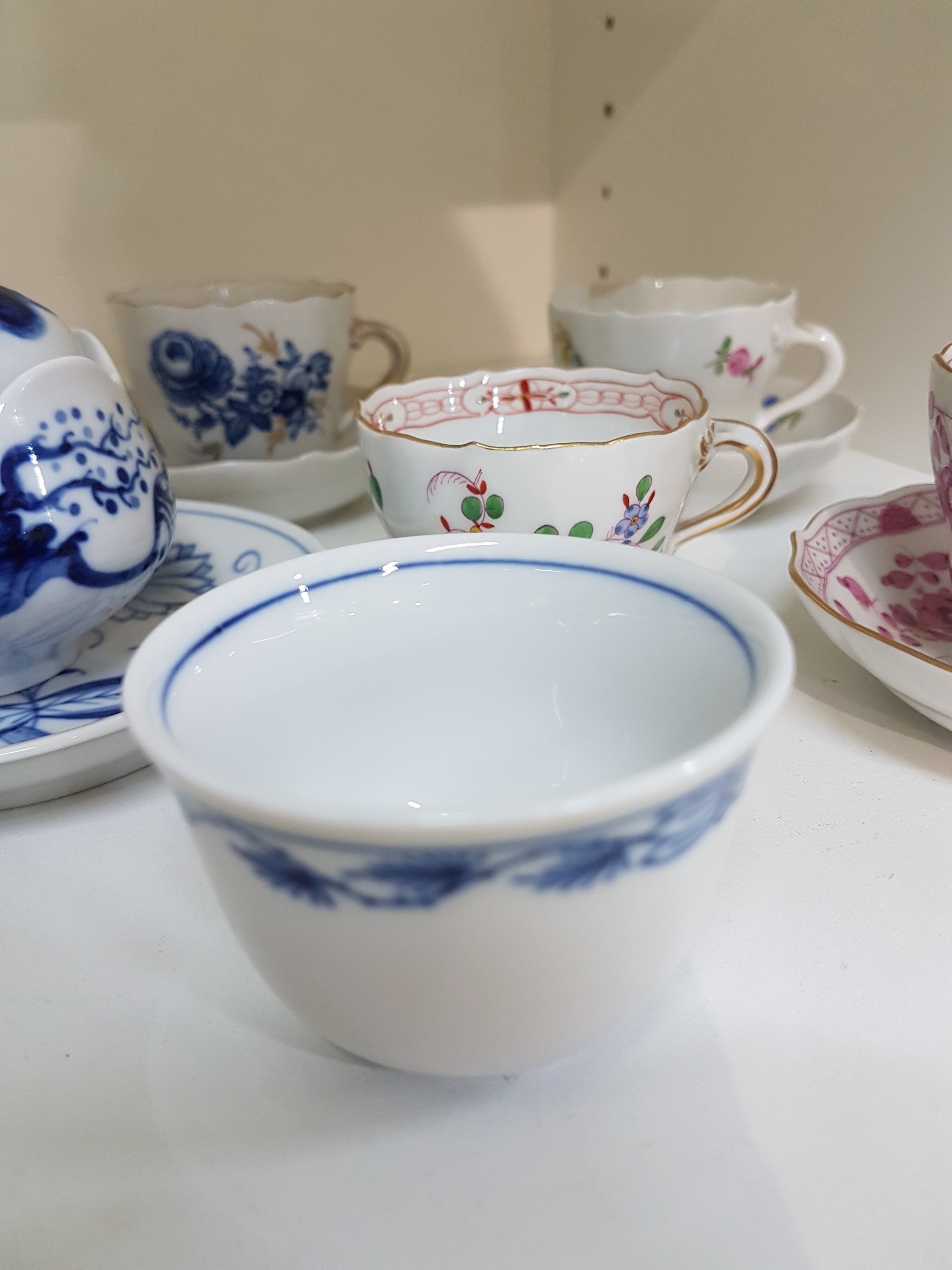 Detail c: 14 Teile Porzellan, Meissen, 20. Jh., 5 Mokkatassen mit Untertassen in den Dekoren Kakiemon, gestreute Blümchen, Indisch purpur, blaue ...