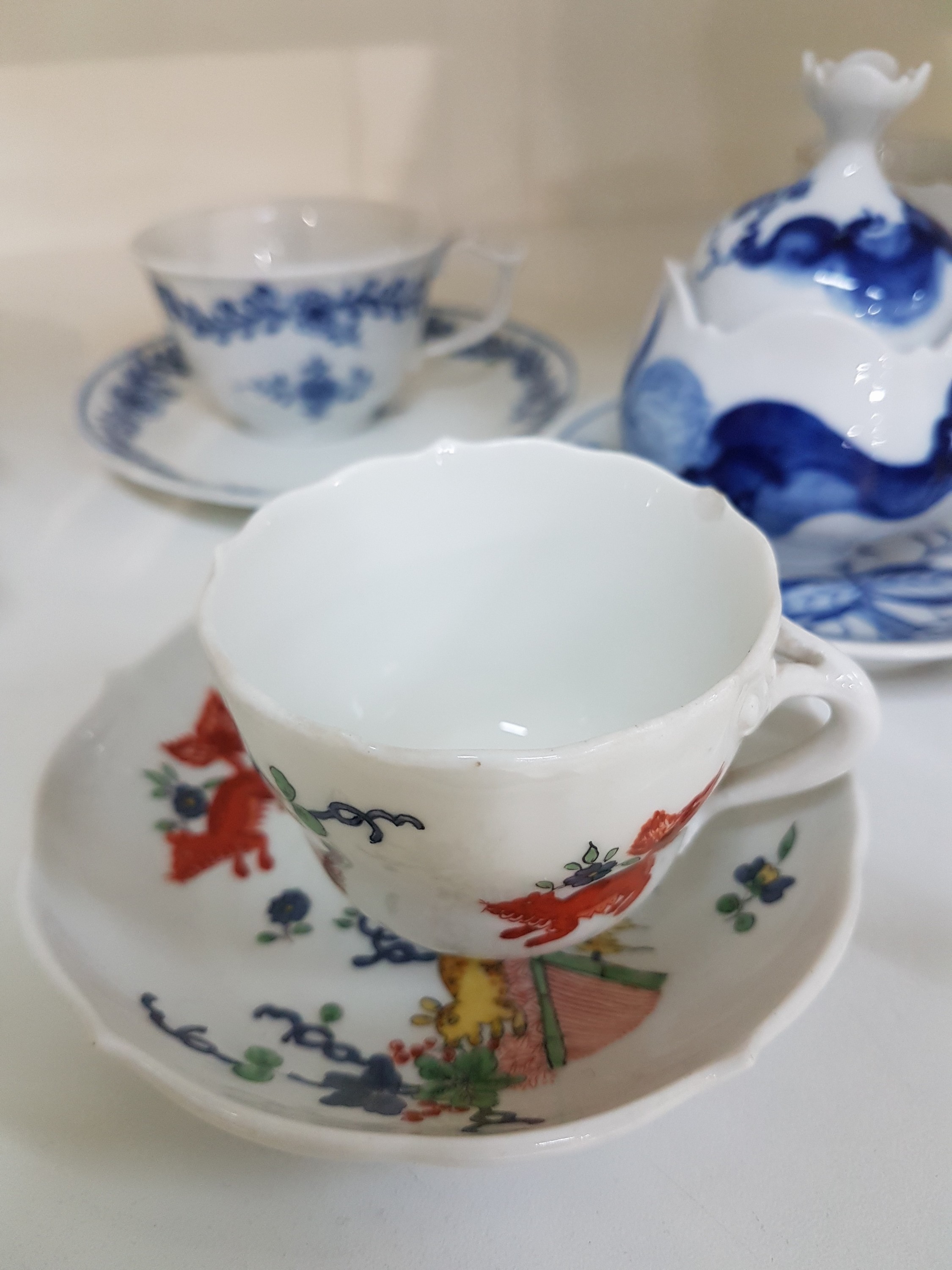 Detail e: 14 Teile Porzellan, Meissen, 20. Jh., 5 Mokkatassen mit Untertassen in den Dekoren Kakiemon, gestreute Blümchen, Indisch purpur, blaue ...