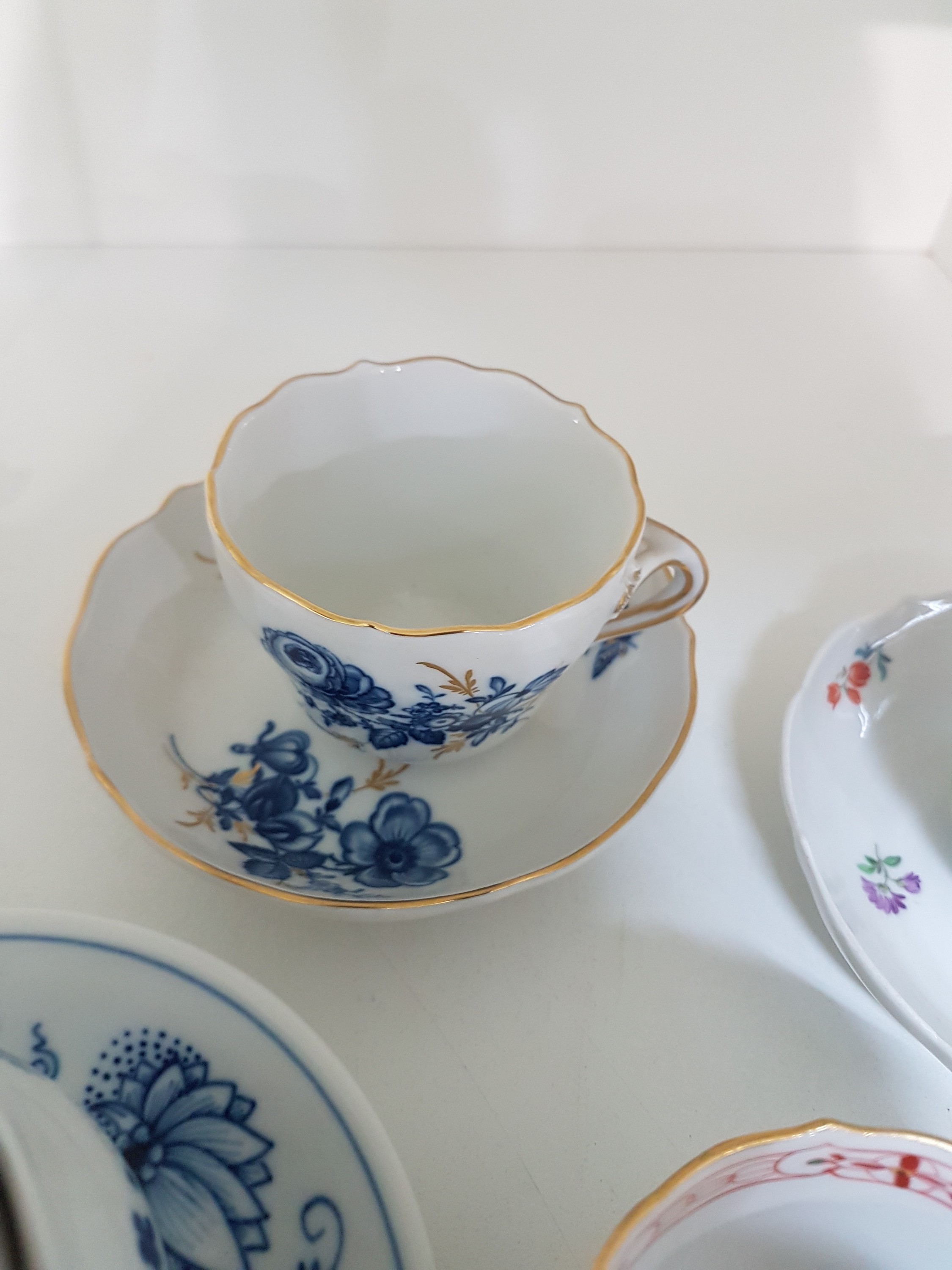 Detail g: 14 Teile Porzellan, Meissen, 20. Jh., 5 Mokkatassen mit Untertassen in den Dekoren Kakiemon, gestreute Blümchen, Indisch purpur, blaue ...