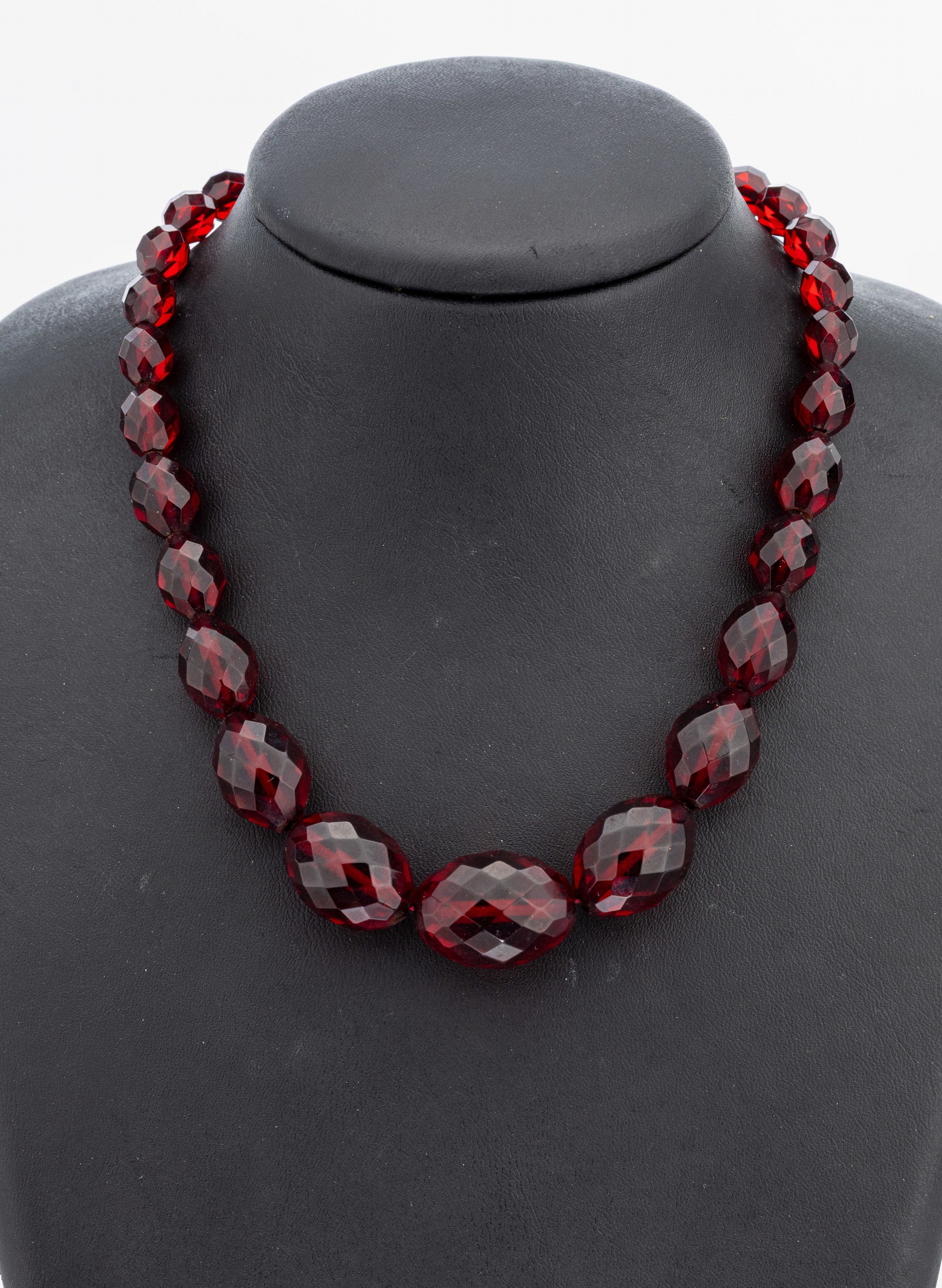 Bernsteincollier, um 1930, rote facett. Bernsteinoliven im Verlauf, L. ca. 8.7 - 23.4 mm, L. ca. 59 cm, Schraubschließe Metall