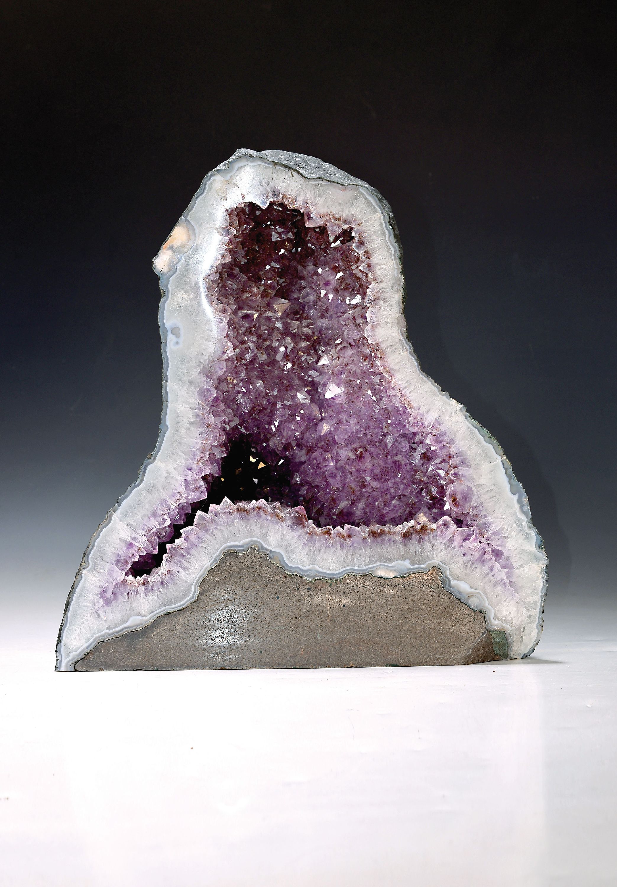 Amethyst-Druse, wohl Brasilien, geschliffeneFront mit weisser Calcit-Rahmung, inneres mit kräftig lavendelfarbenen Amethyst-Kristallen, guter ...