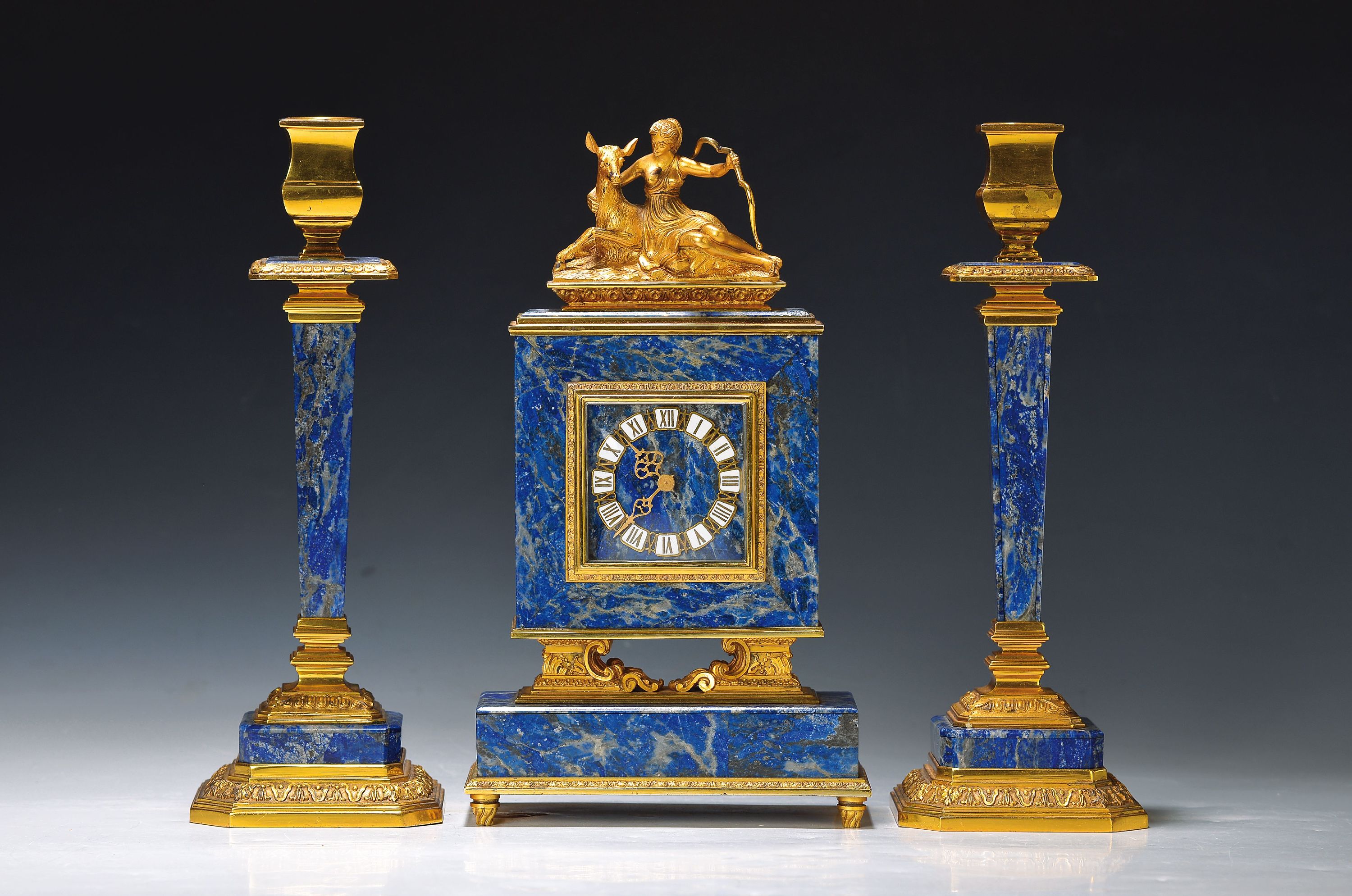 Tischuhr mit zwei Kerzenleuchter Beistellern, Schweiz um 1920/30, elegantes Lapislazuli-Gehäuse mit vergoldeten Silbermonturen, vollplastische ...