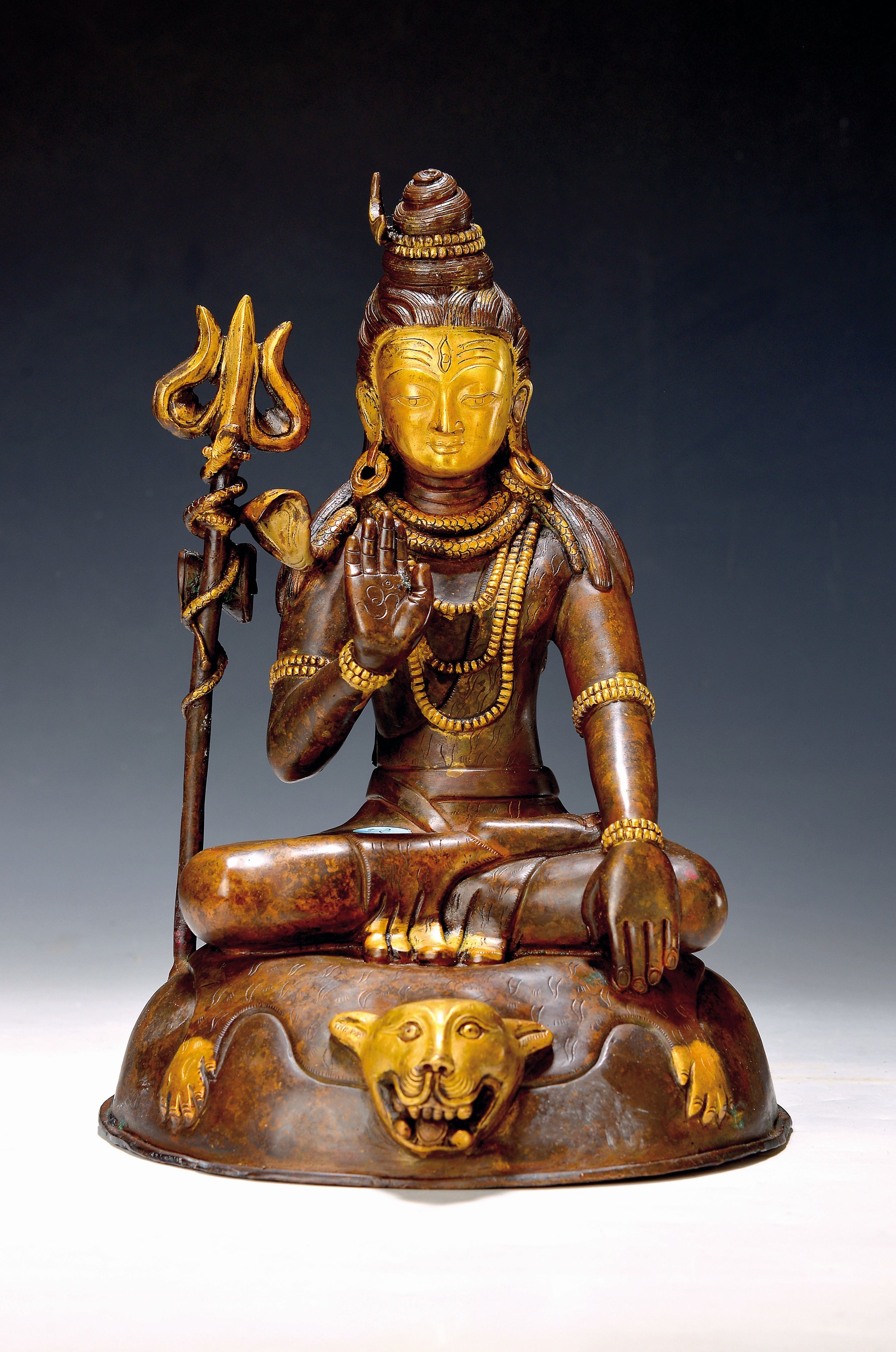 Gottheit Shiva, Tibet, wohl um 1950, Dreizack und auf Löwenfell sitzend, Kupferlegierung, partiell vergoldet, H. 34 cm, ca. 4.2 kg