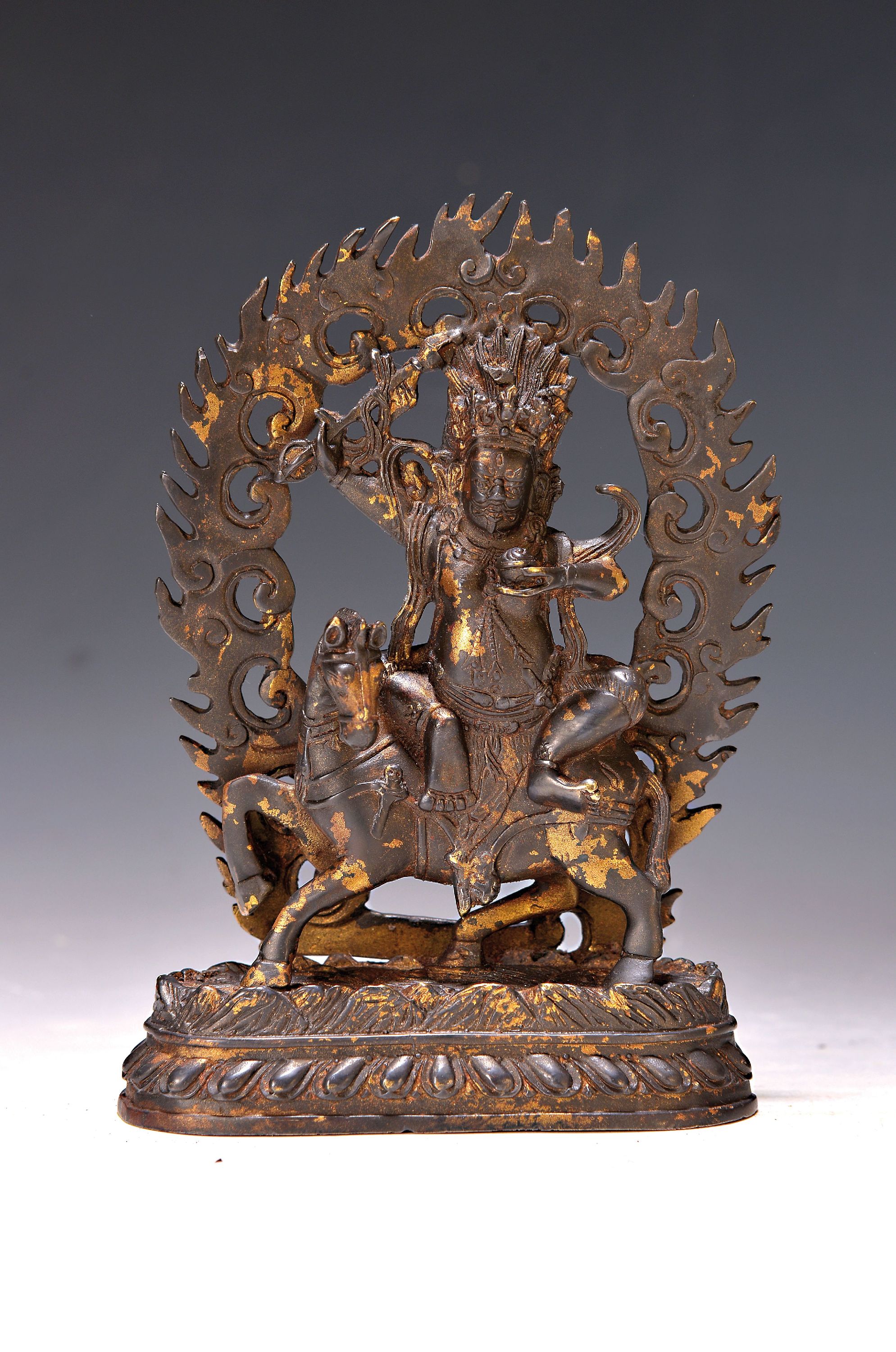 Palden Lhamo auf Maultier, Nepal wohl 20.Jh. , Kupferlegierung vergoldet, über den Blutsee seiner Feinde reitend, mit Schädelkeule und ...