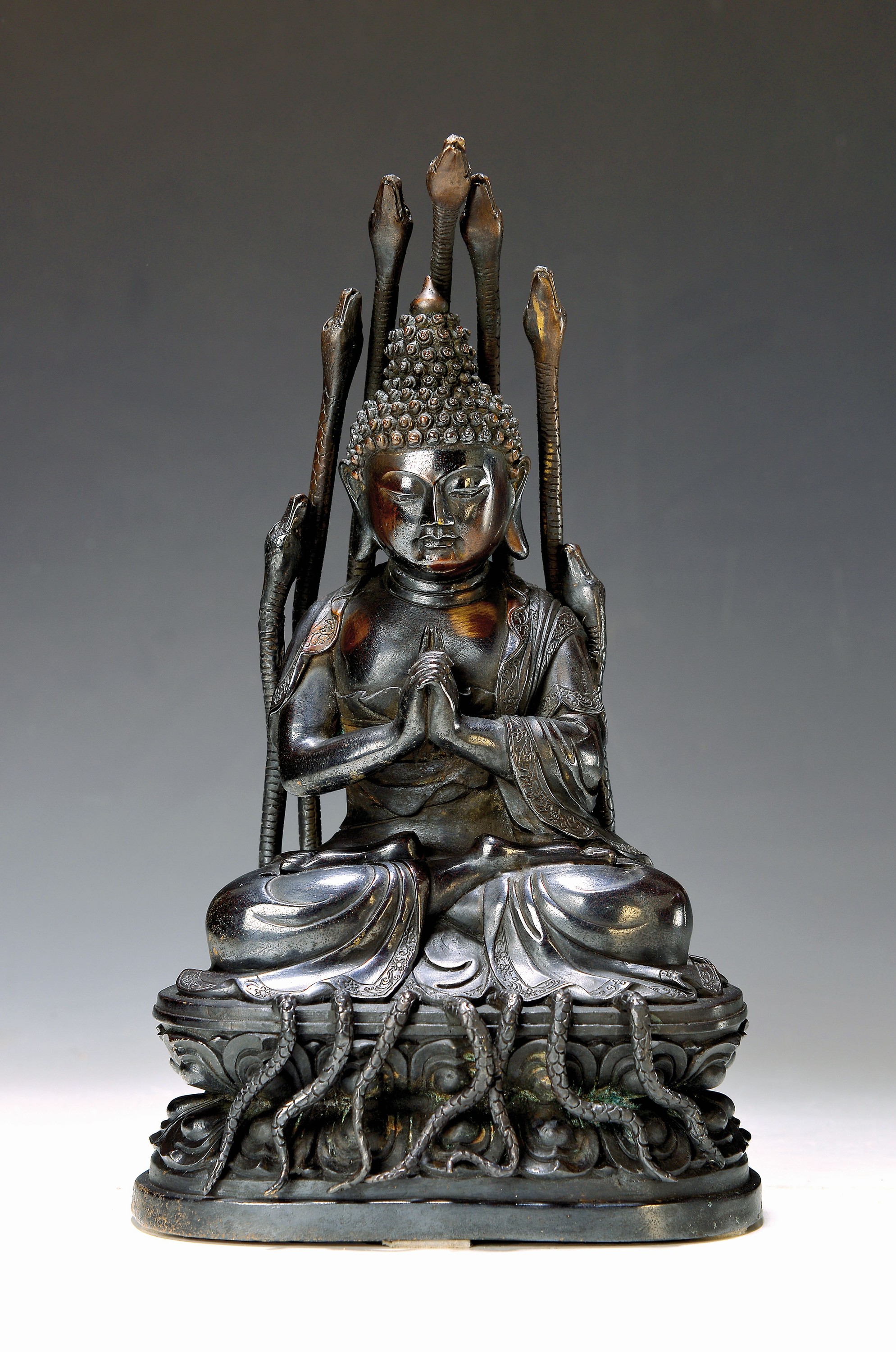 Gautama Buddha, China 20. Jh., silberhaltige Bronze, partiell vergoldet, beschützt von sieben Schlangen während der Meditation, H. 32 cm