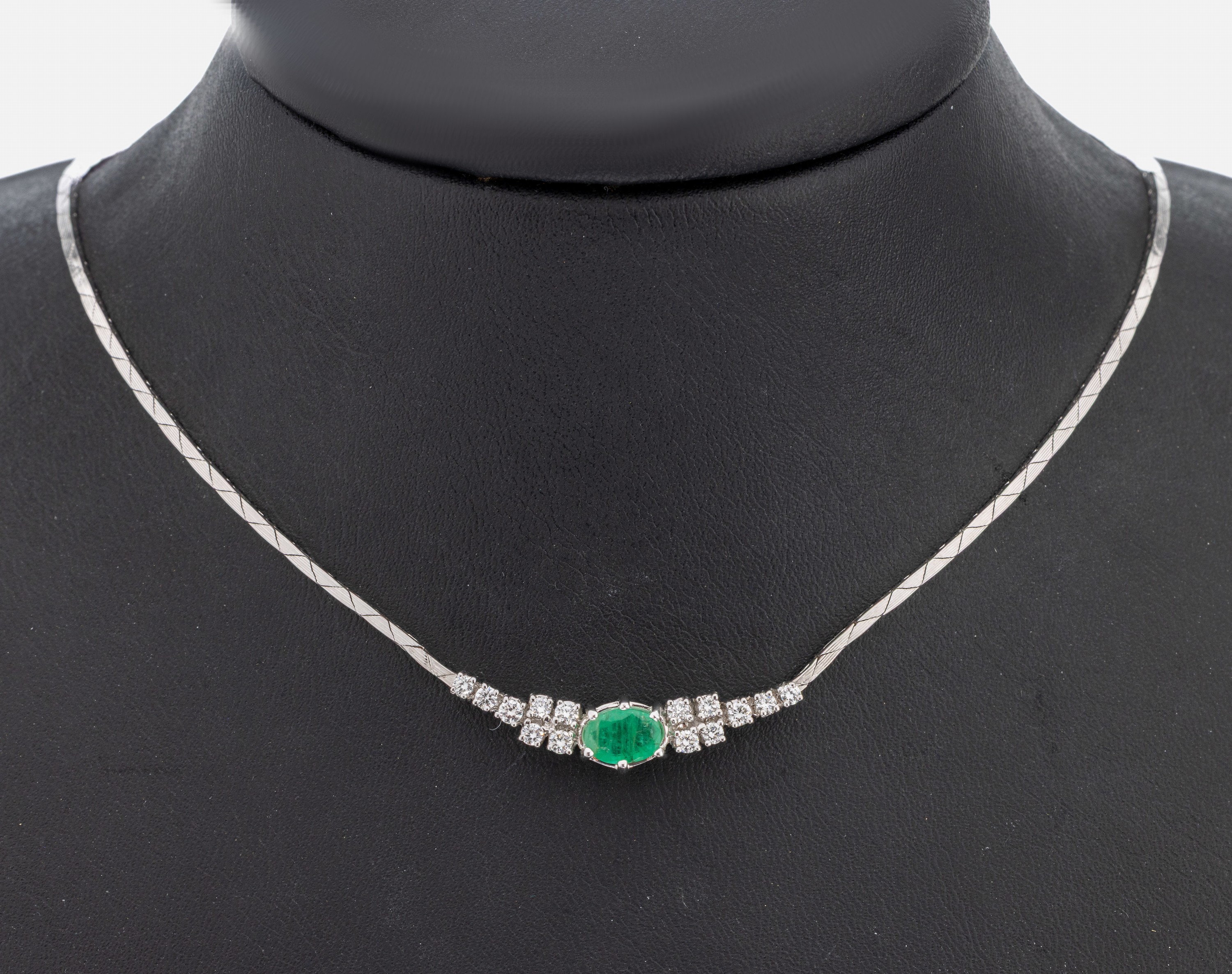 14 kt Gold Smaragd-Brillant-Collier, WG 585/000, Mittelteil mit ovalfacett. Smaragd ca. 0.50 ct, seitl. 14 Brillanten zus. ca. 0.46 ct feines ...