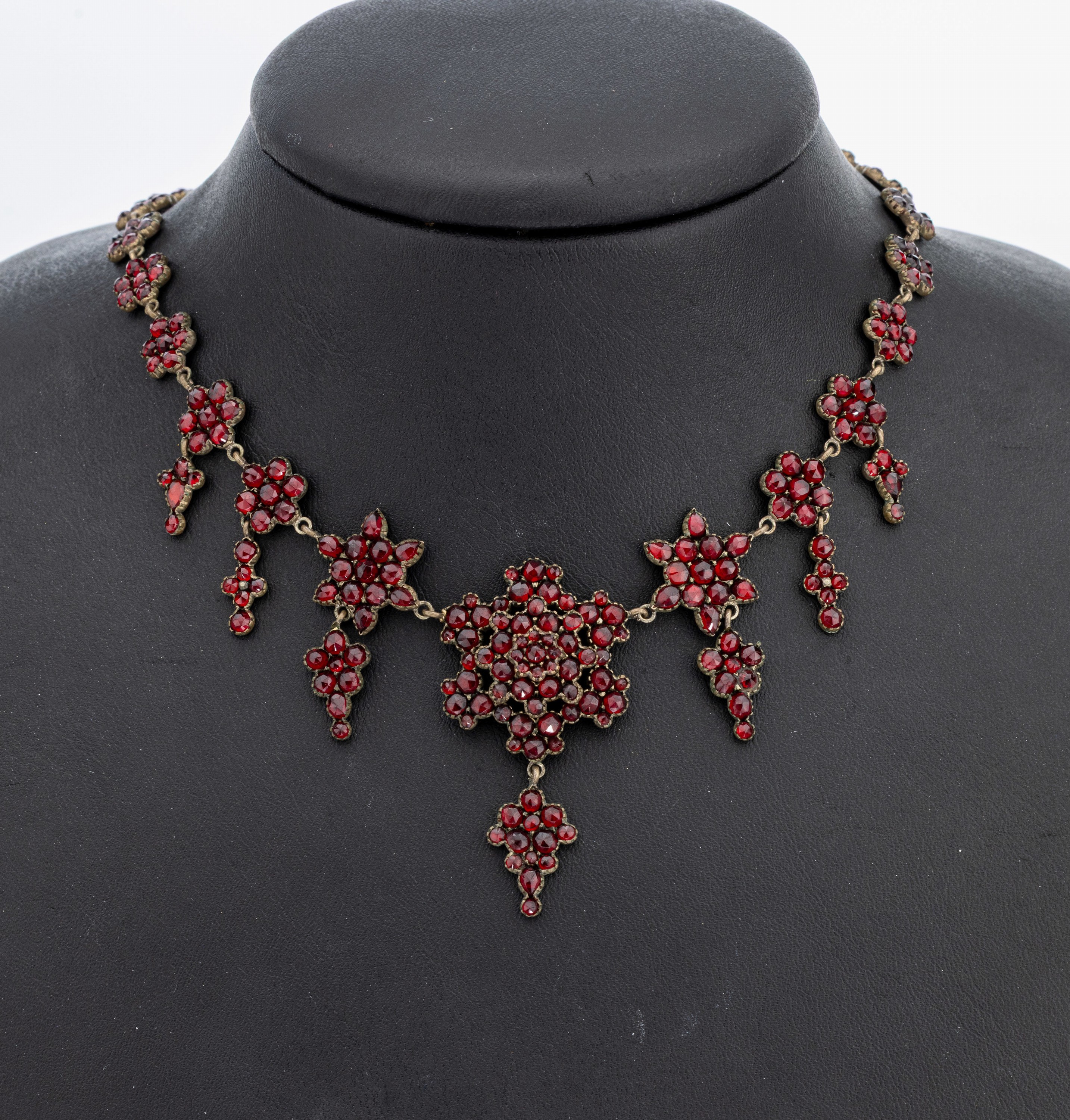 Granatcollier, Böhmen um 1880, Tombak, florale Elemente, bes. mit rundfacett. Granaten von schöner Farbe, L. ca. 49 cm, Kastenschloss mit ...