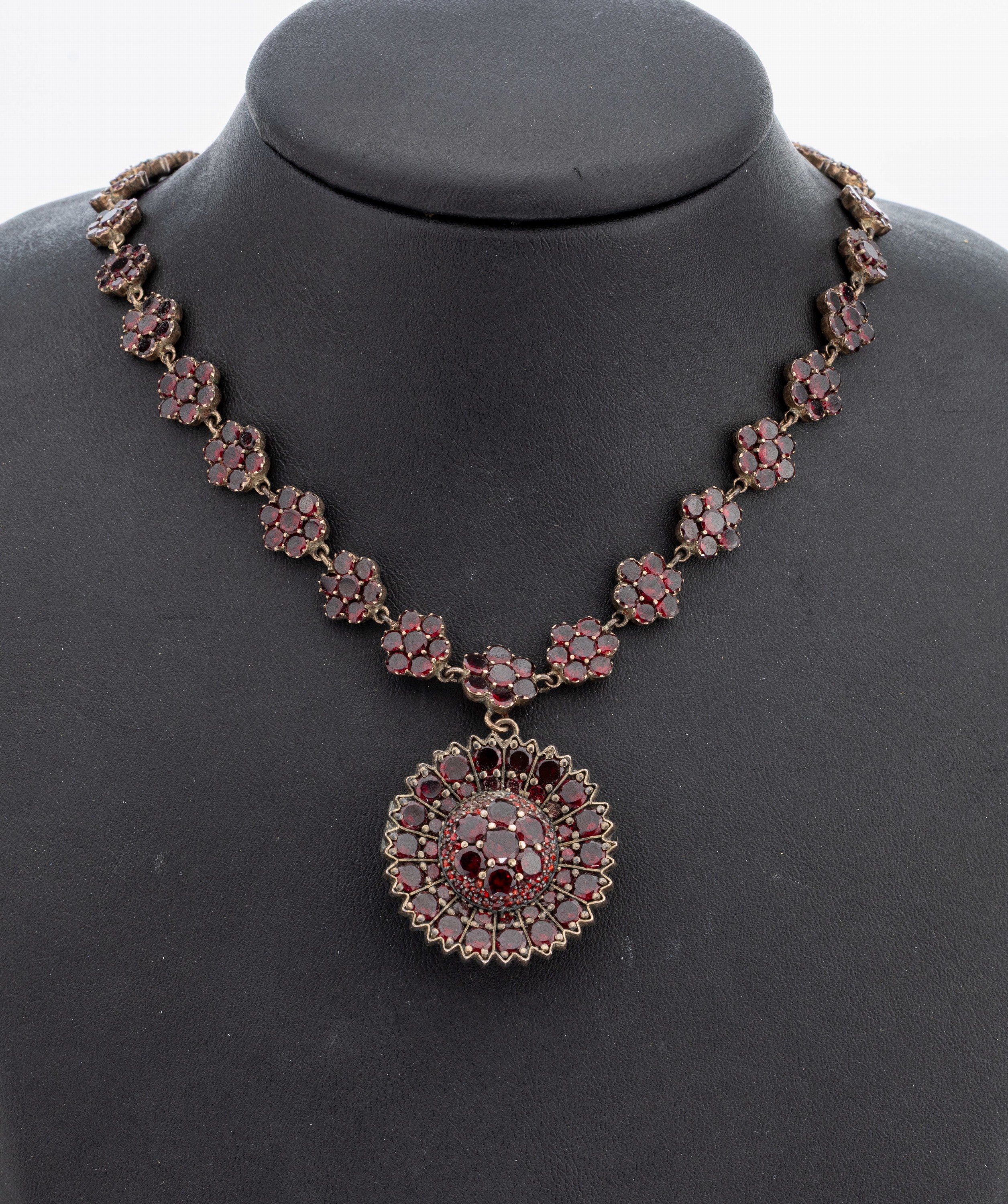Granat Collier, Böhmen um 1910, Tombak verg., blütenförm. Elemente mit Spiegelgranaten, Mittelteil mit bewegl. Abhängung, auch abnehmbar und als ...