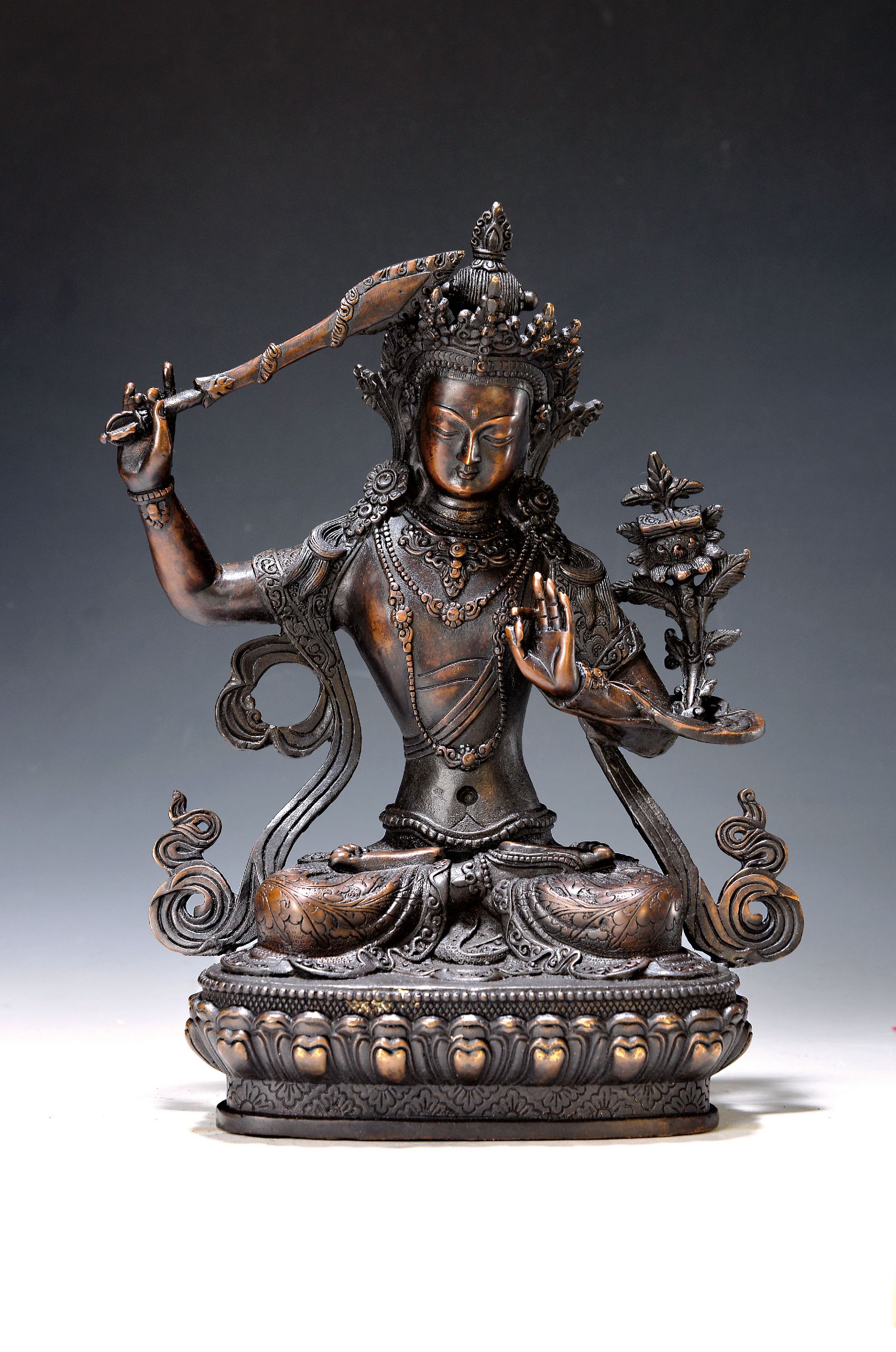 Bodhisattva/Manjushri, Nepal, 20. Jh., Kupferlegierung, mit erhobenem Schwert und Lotus, auf Lotussockel, H. ca. 30 cm