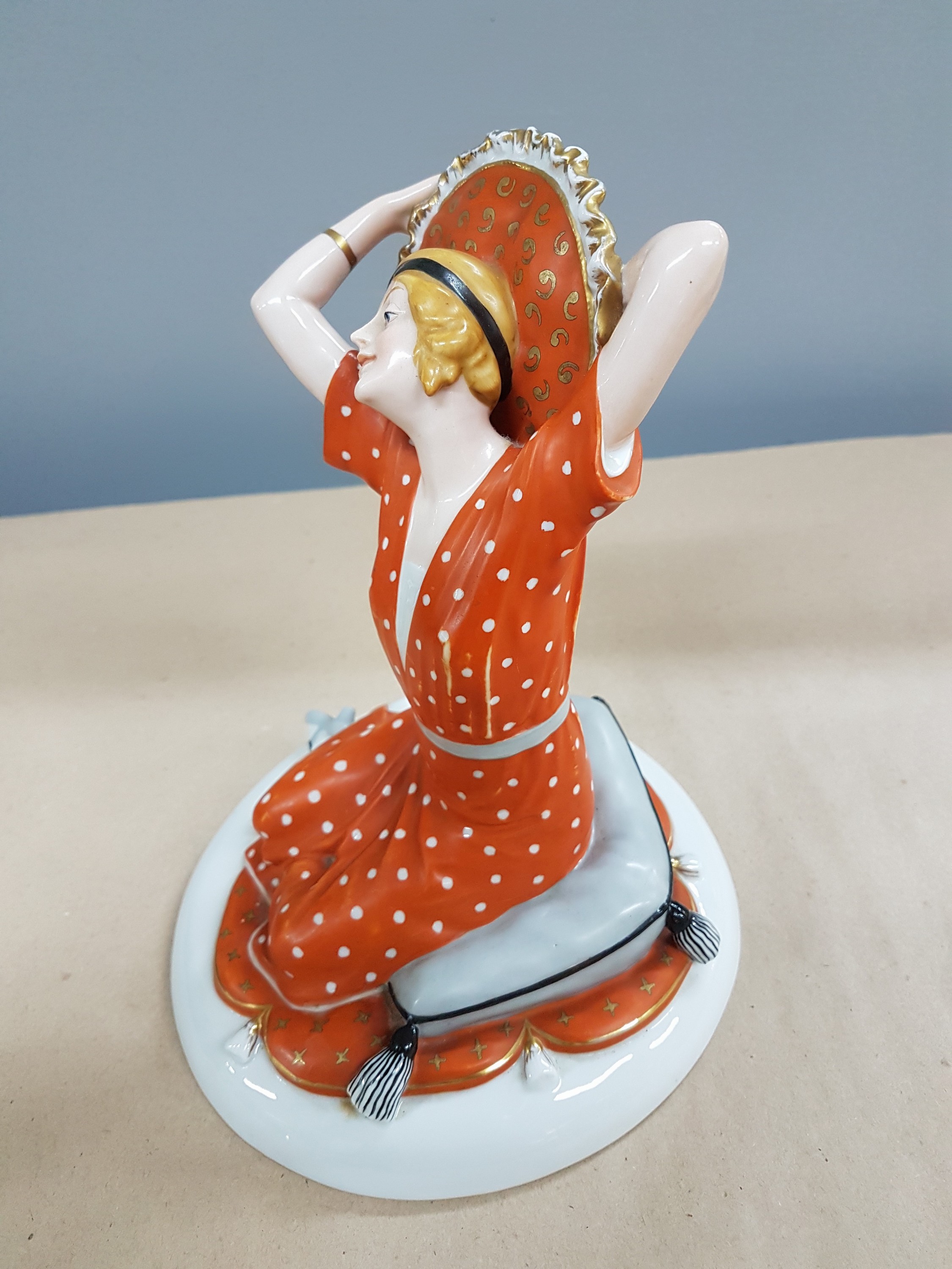Detail d: Porzellanfigur, Fraureuth Kunstabteilung, Entwurf Eugen Dotterweich, junge Frau auf einem Kissen sitzend, ein weiteres Kissen hinter ihren Kopf ...