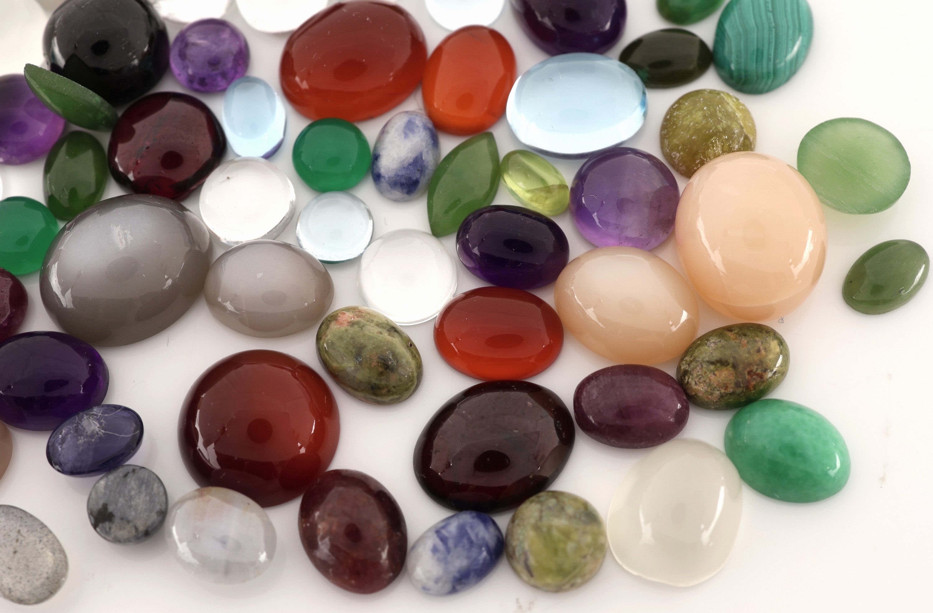 Detail b: Lot lose Farbsteincabochons, zus. 84.59 ct,versch. Größen und Formen, u.a. Amethyst, Malachit, Blautopas (beh.), u.v.m.