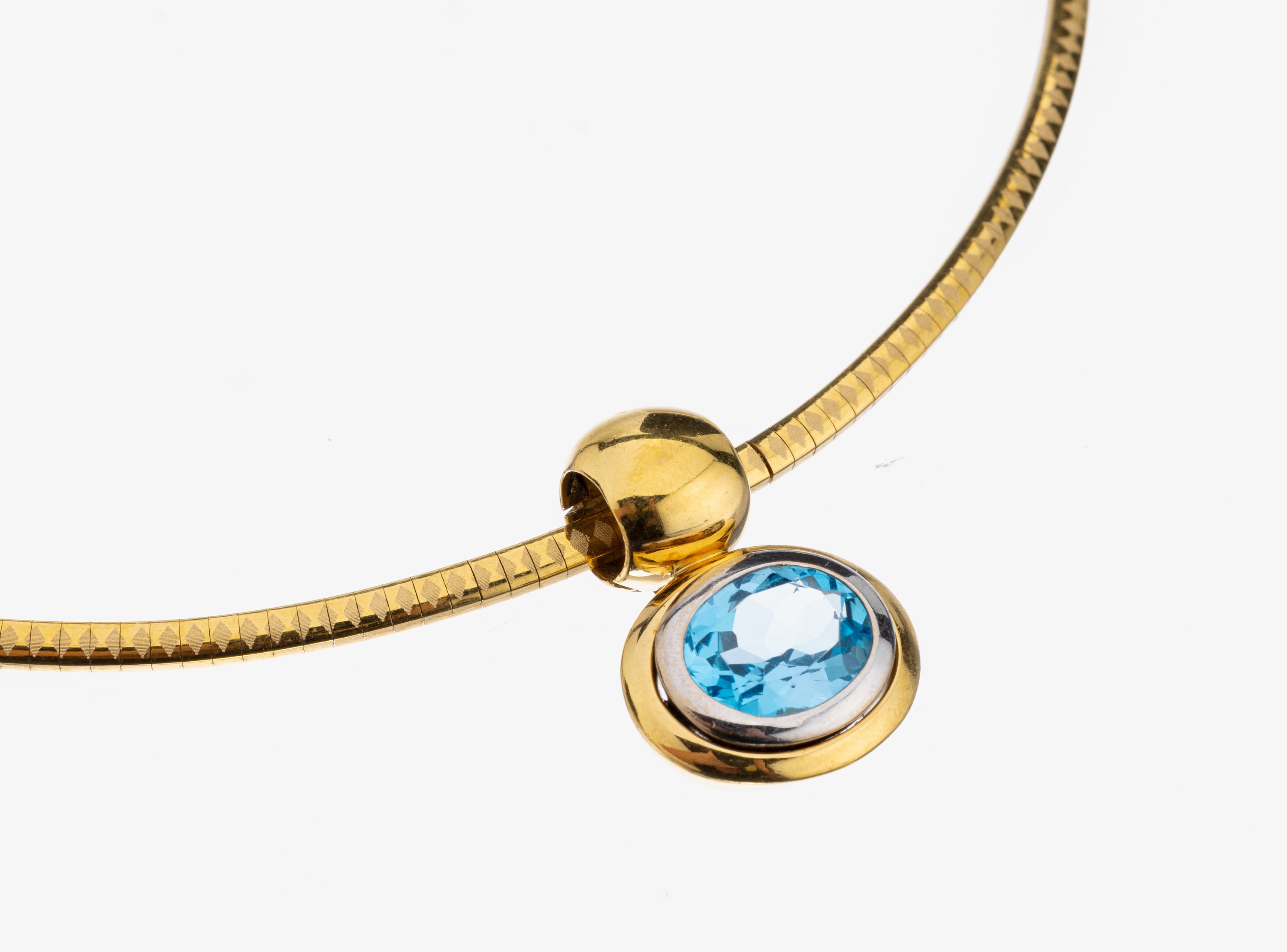 18 kt Gold Blautopas-Anhänger, GG/WG 750/000, in WG gefasster ovalfacett. Blautopas(beh.) ca. 6.50 ct, ca. 33.5 g, an Omegareif, L. ca. 40 cm, ...