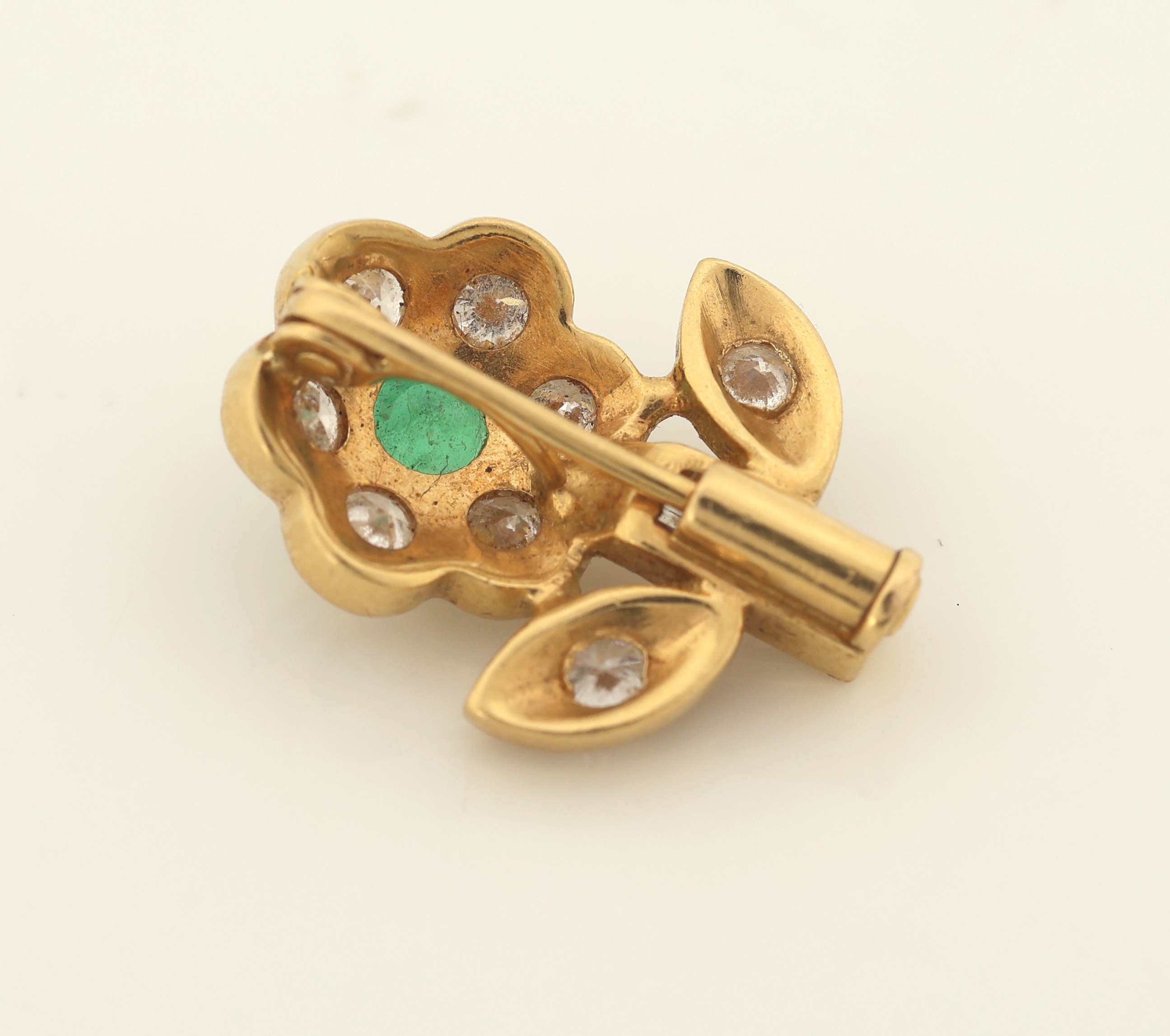 Detail a: 18 kt Gold Smaragd-Diamant-Brosche "Blume", GG 750/000 gepr., rundfacett. Smaragd ca. 0.15 ct, 8 Brillanten und 2 Diamantbaguettes zus. ca. ...