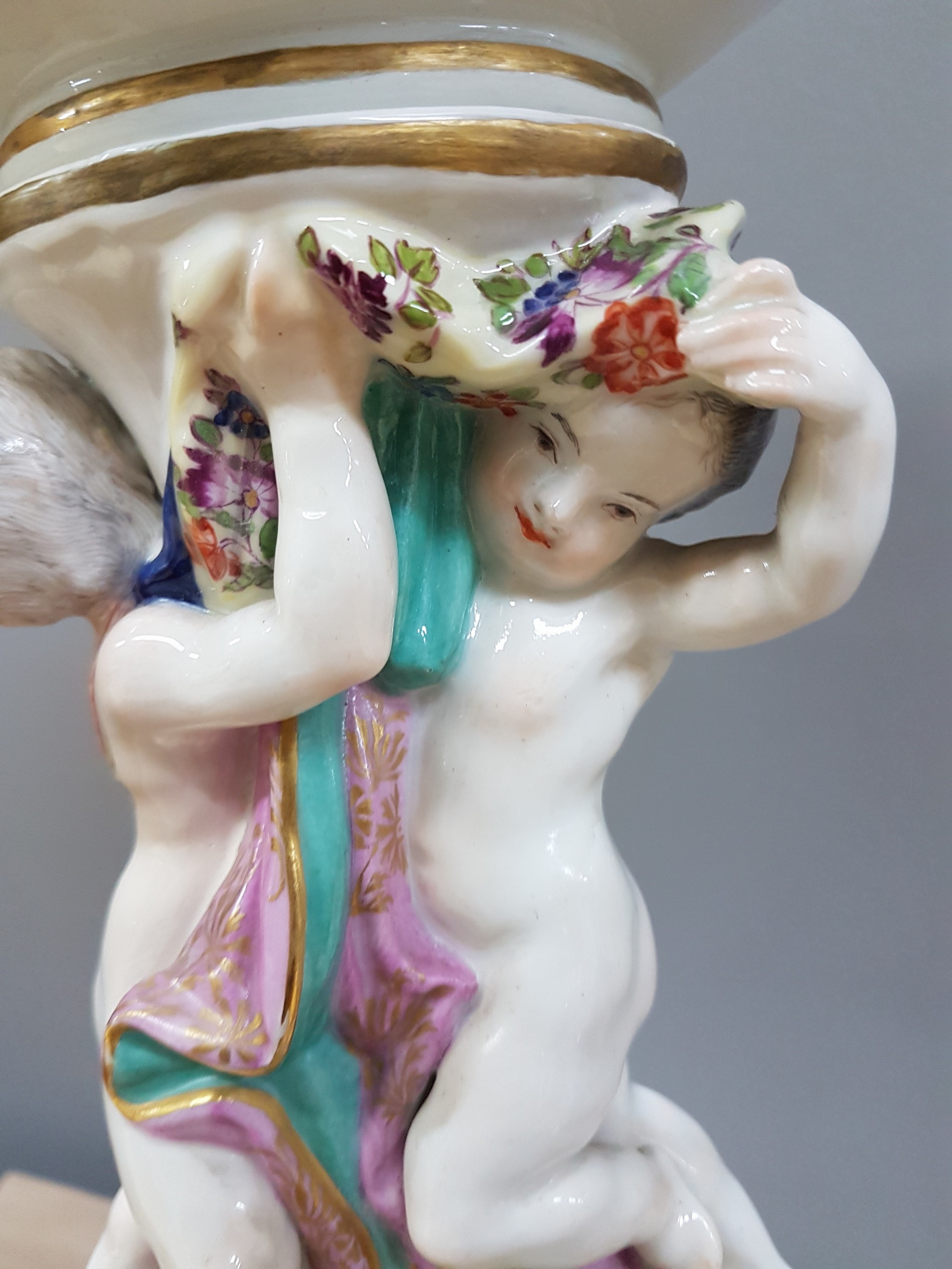 Detail c: Figürlicher Tafelaufsatz, Meissen, um 1740, zwei Putten auf stammähnlichem Sockel stehend mit Geäst und applizierten Blüten, Korbschale mit ...